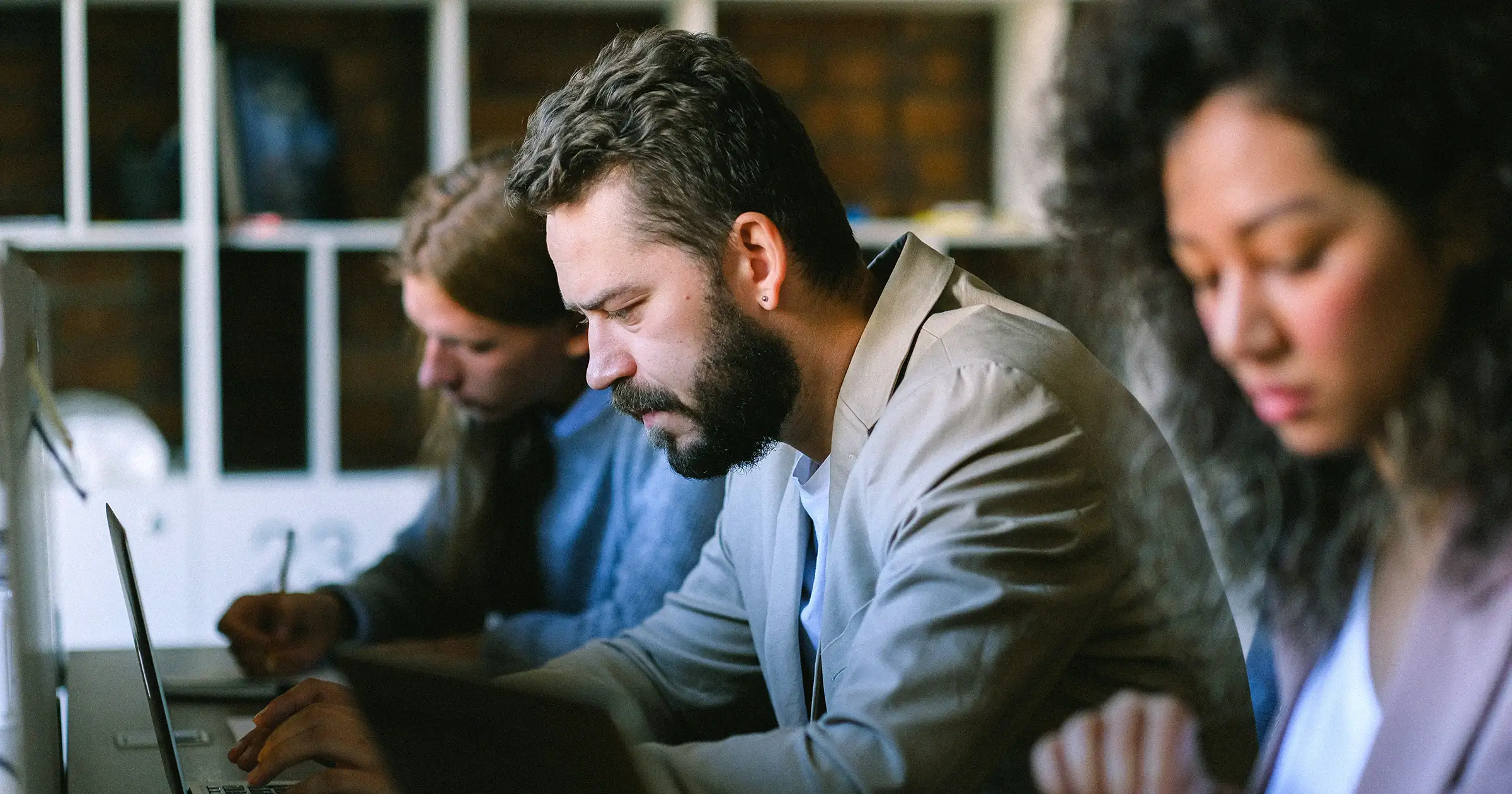 3 people hard at work on their computers