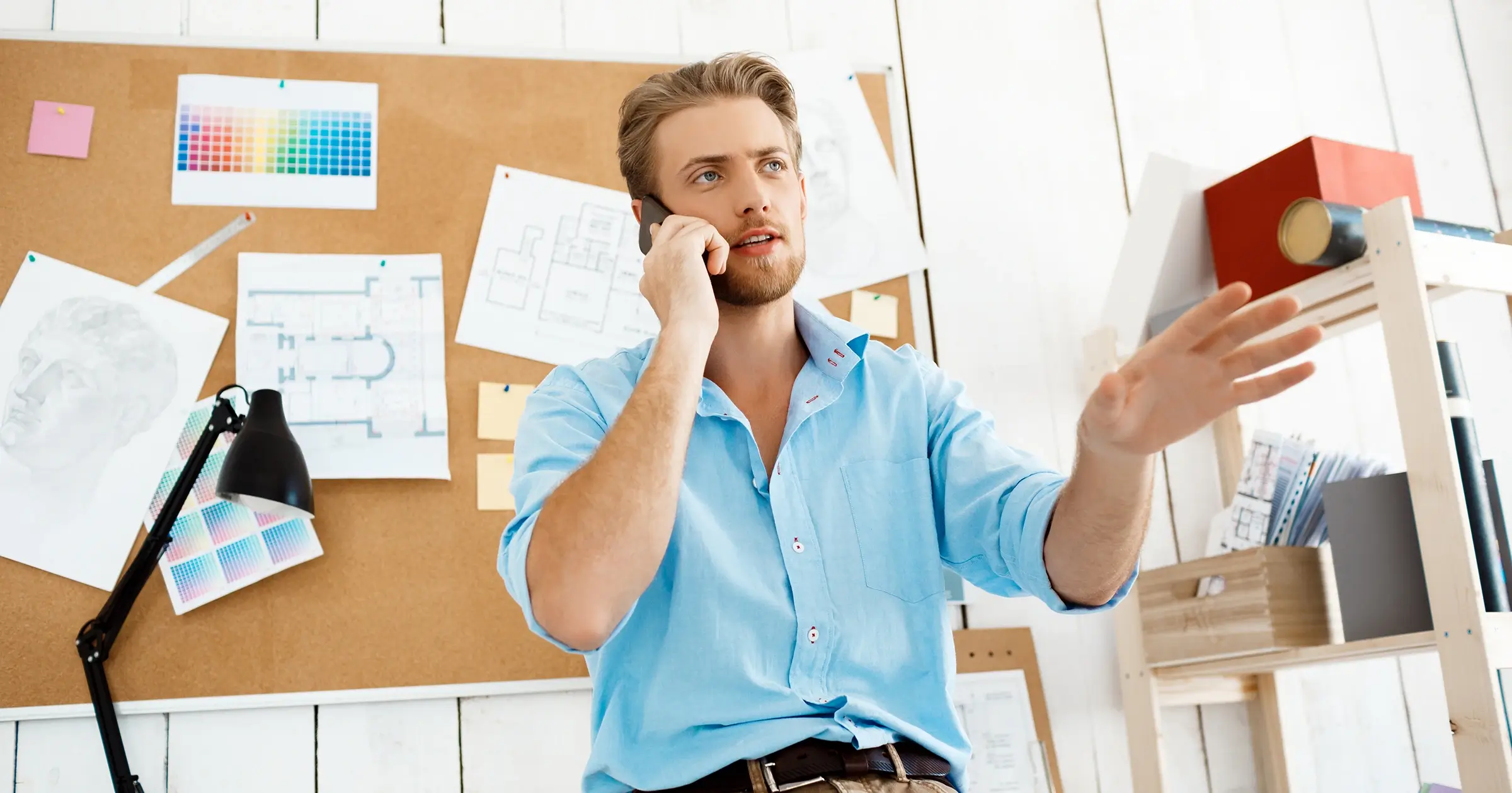 Man leaning on a desk on a phone call