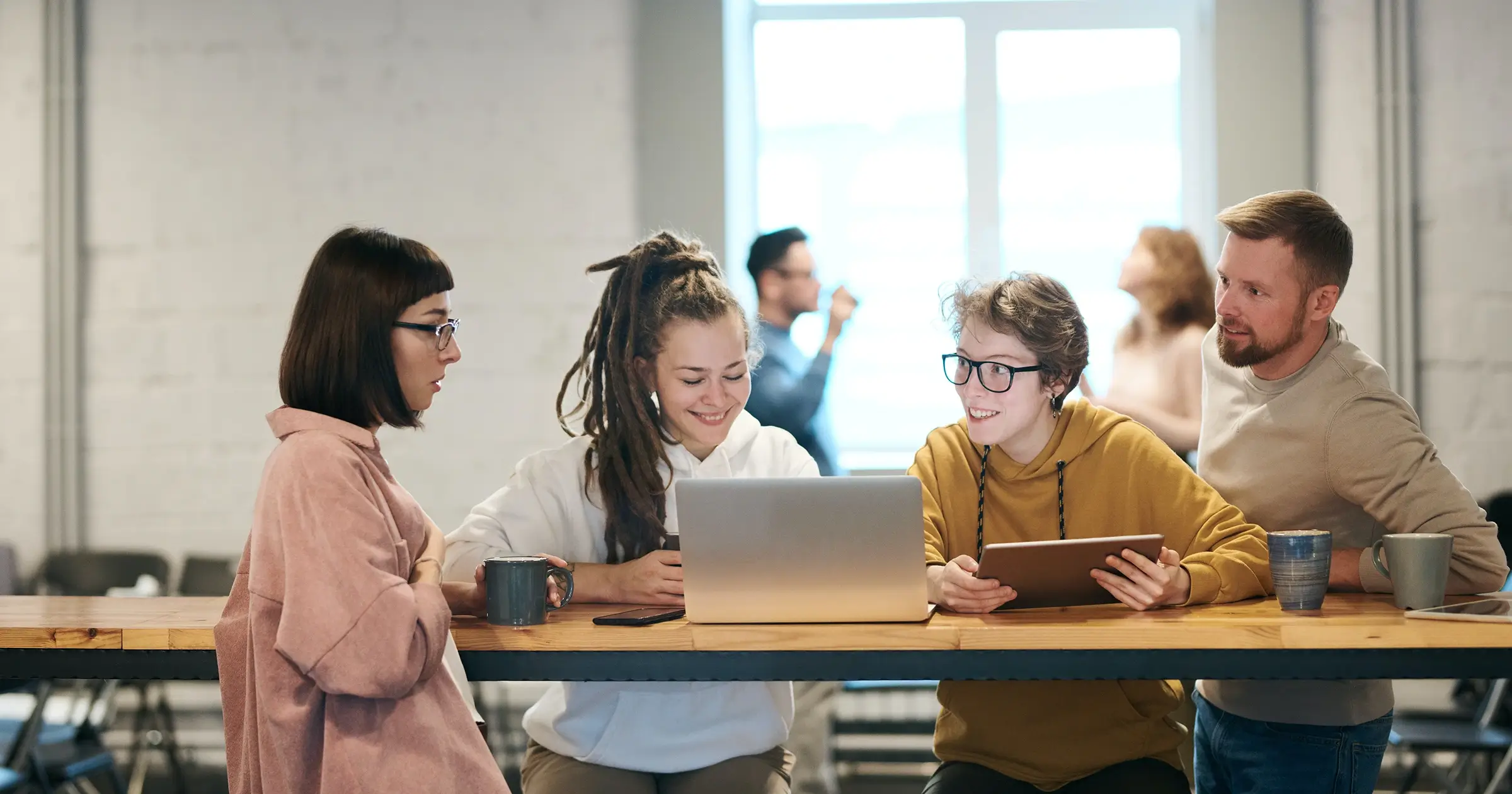 4 freelancers at a high wooden desk