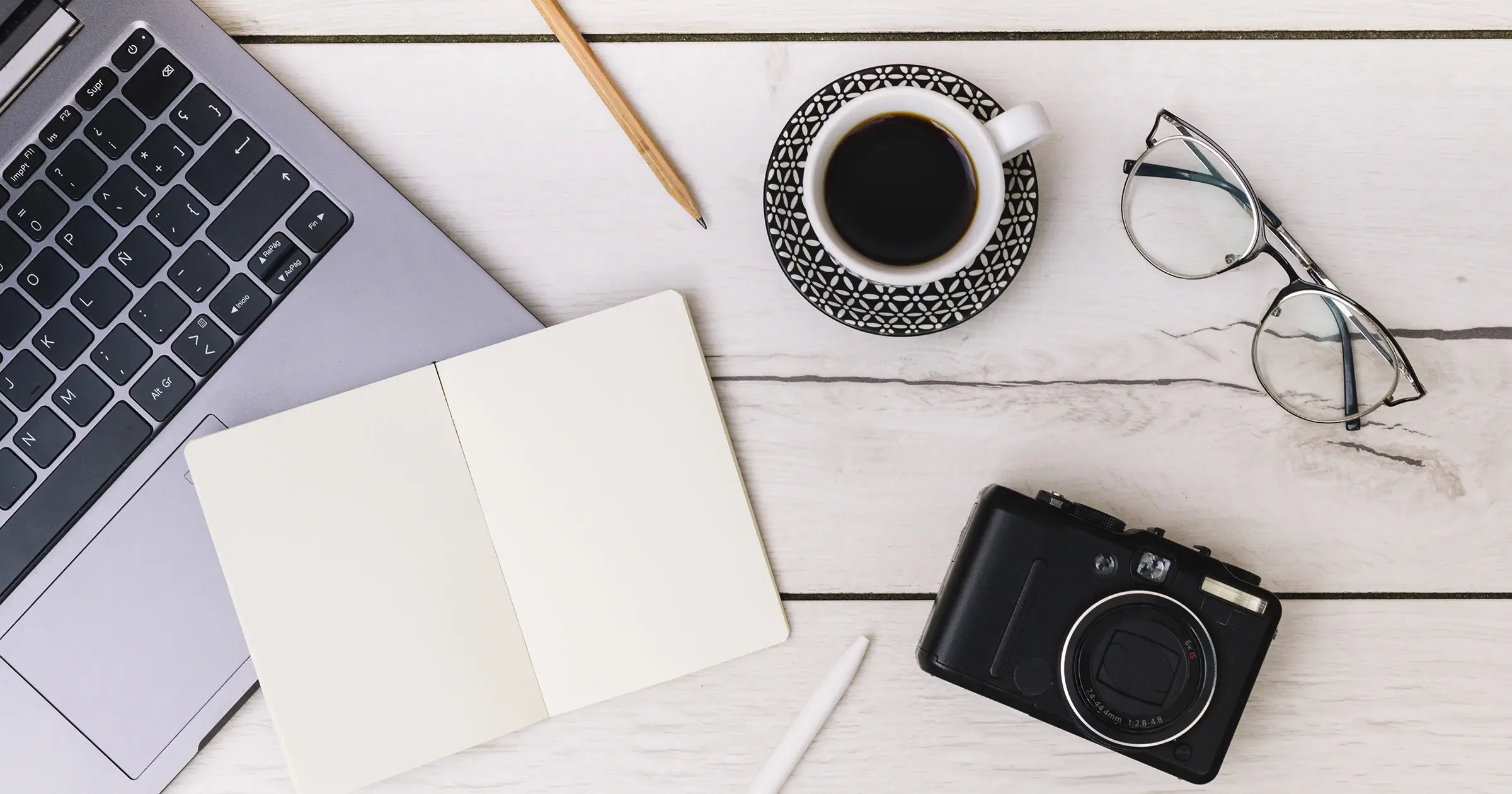 Desktop with laptop, glasses and camera