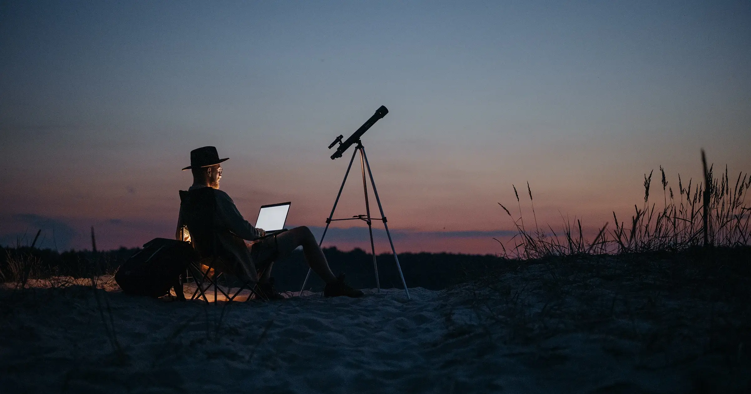 A man with a laptop in nature at night