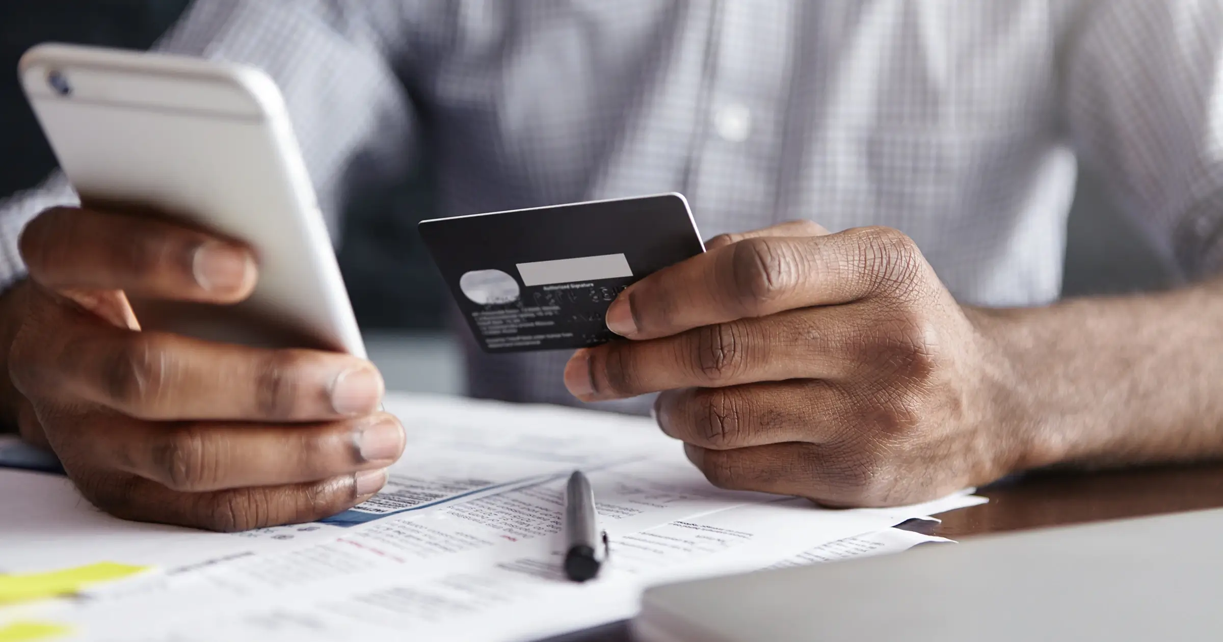 Man holding a phone and a credit card