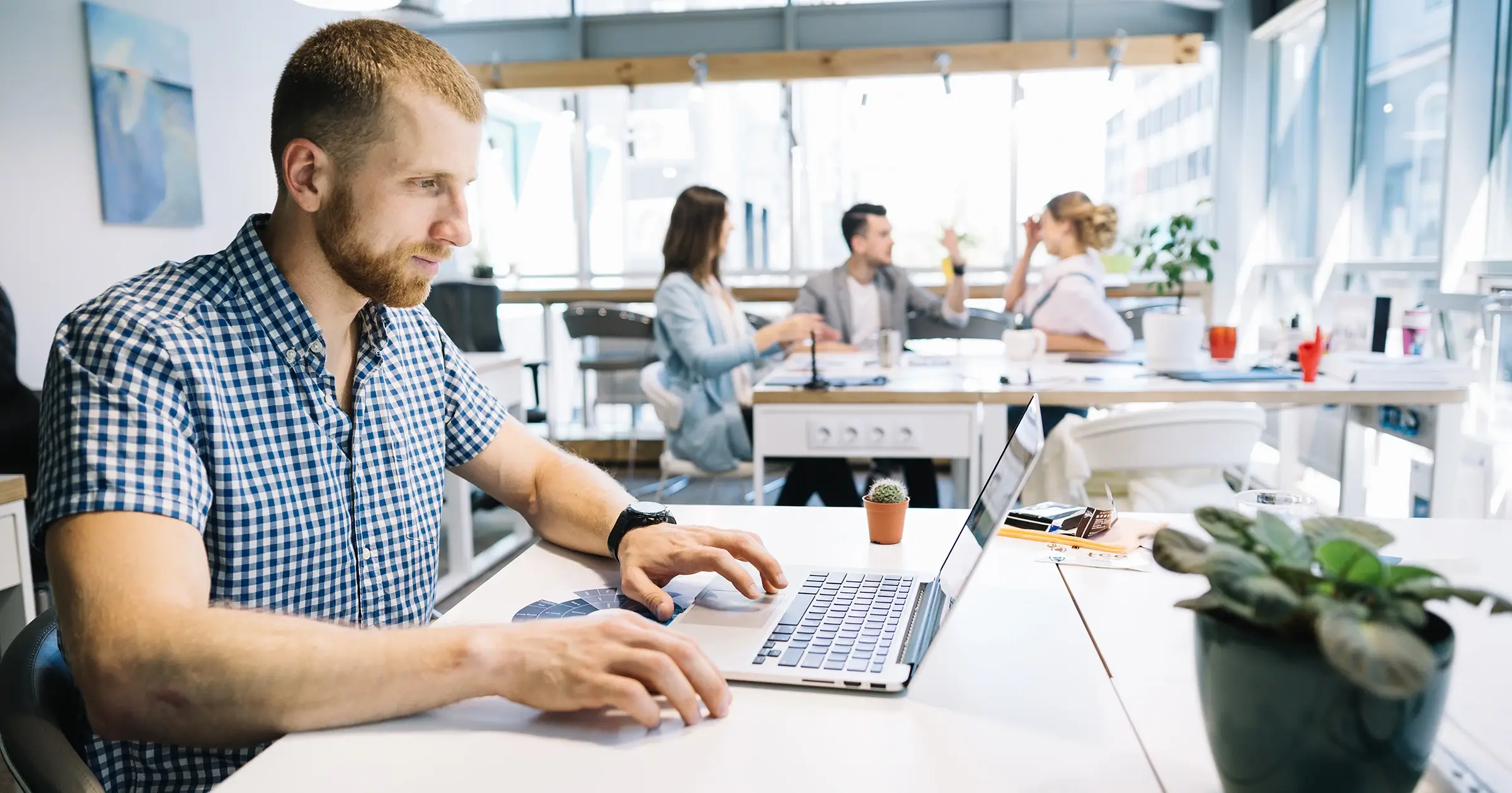 Freelancer working alone with other workers in the background