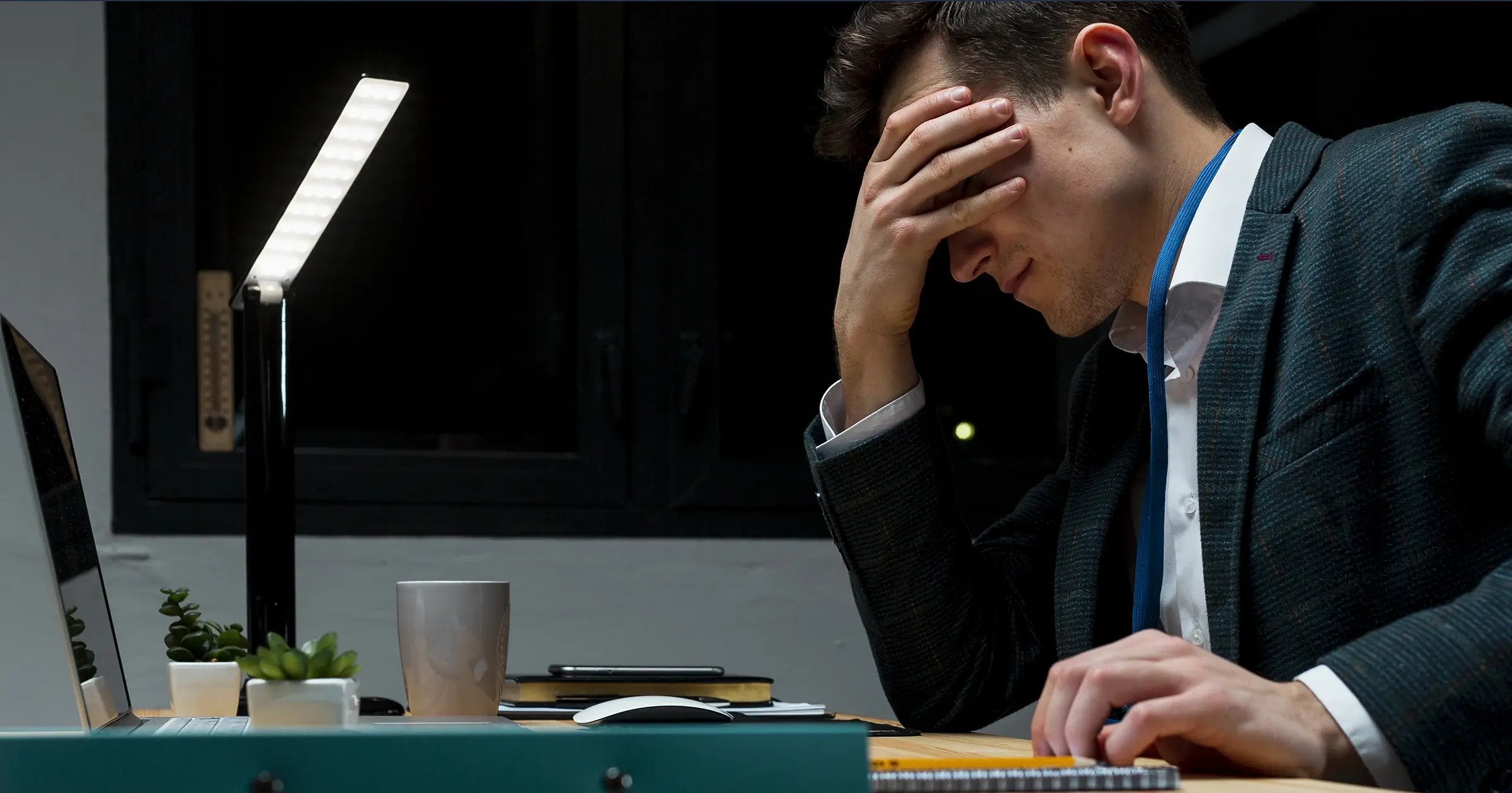 Disappointed man holding his head in front of his computer