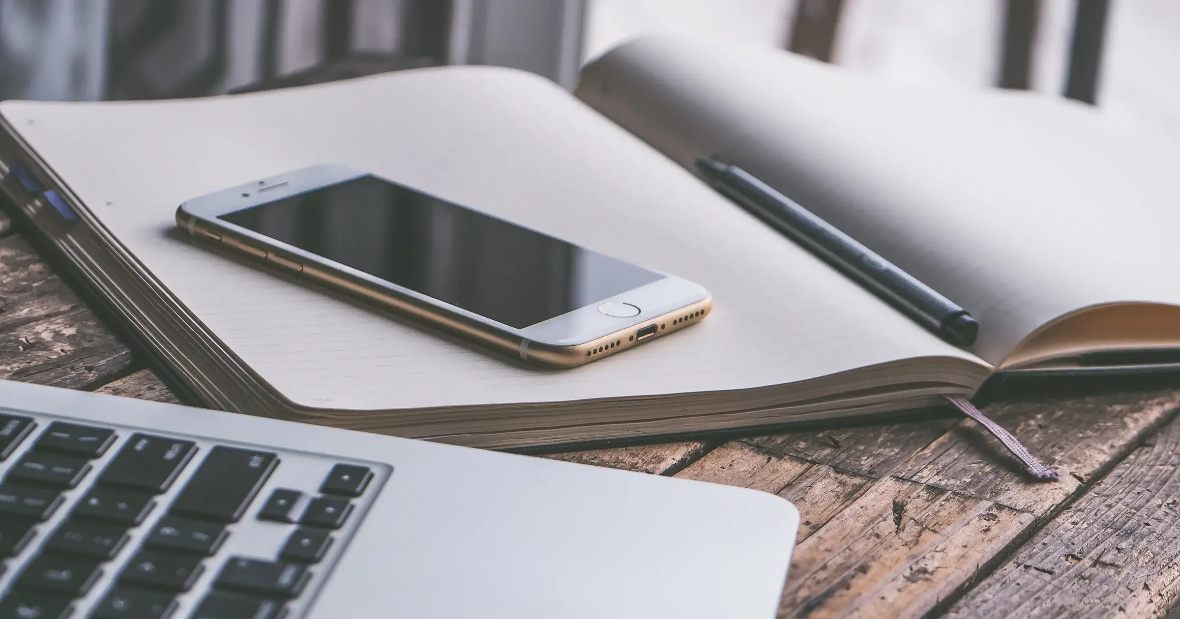 Laptop, iphone and book on a desk