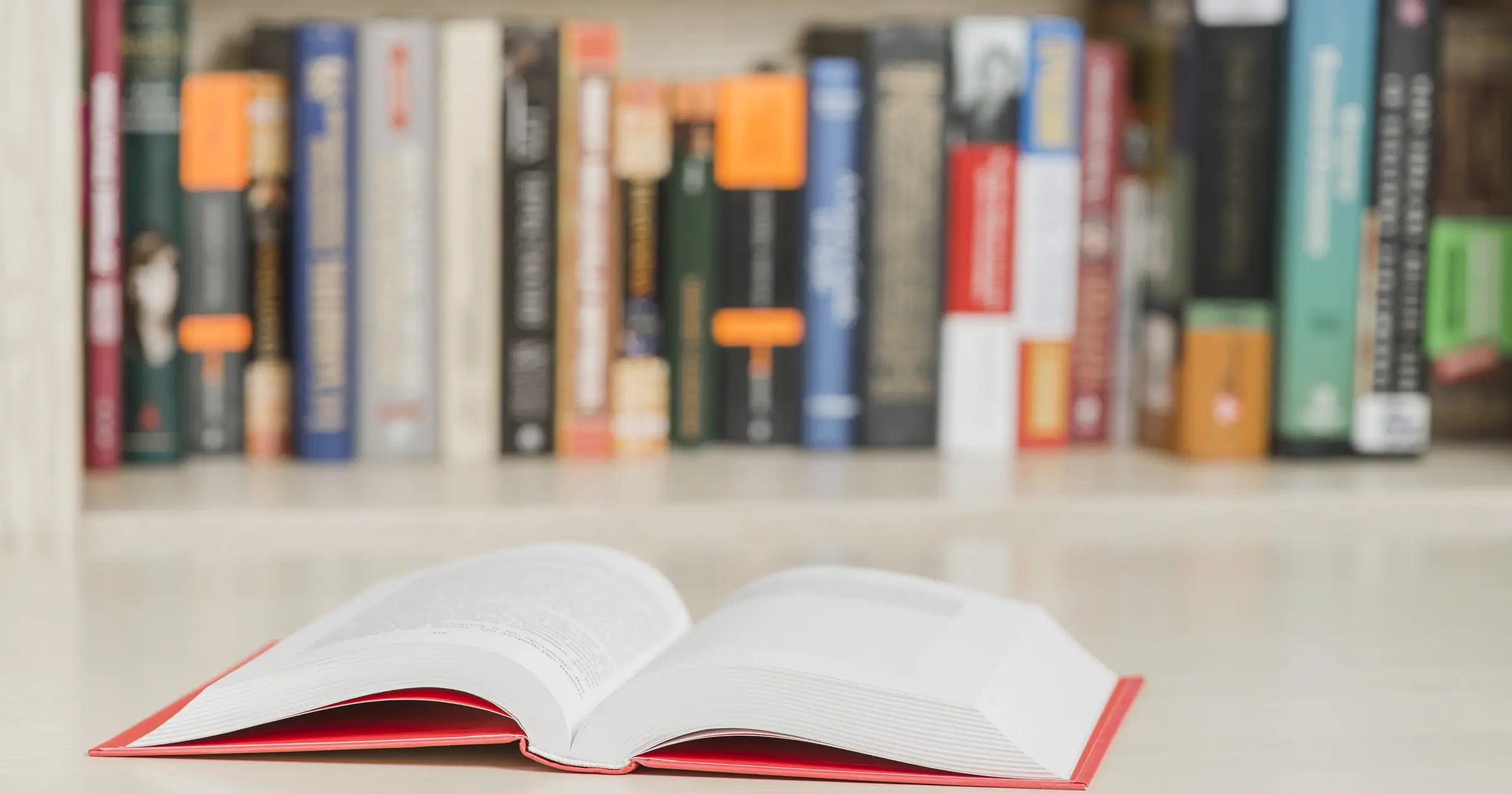 An open book in front of a shelf