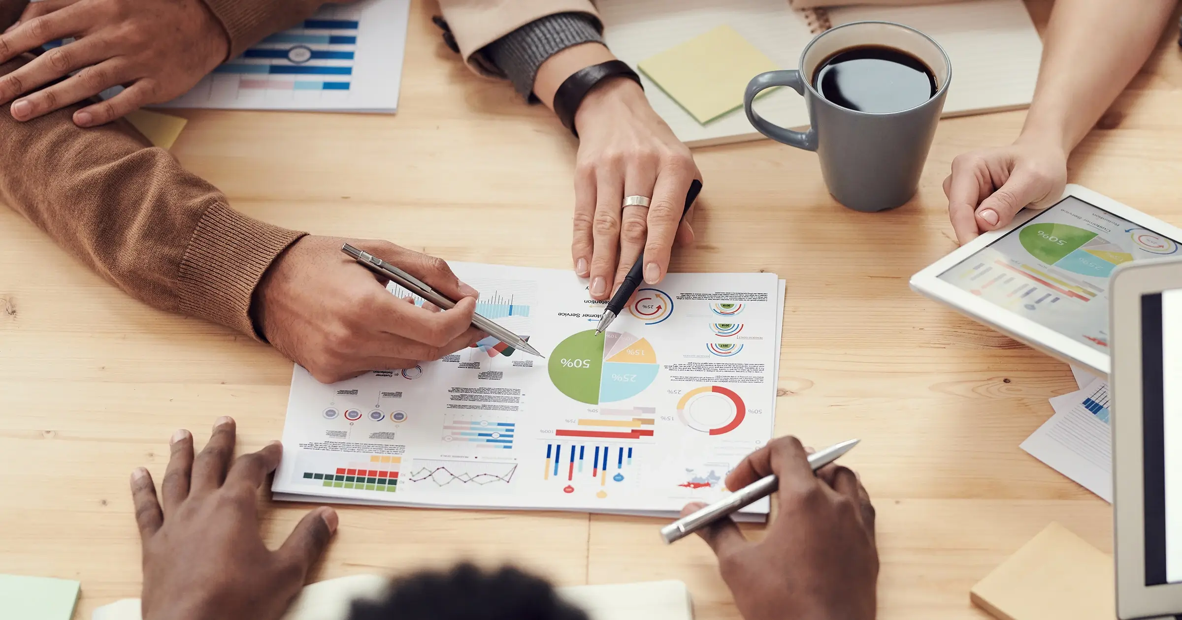 3 people looking at charts on a desk