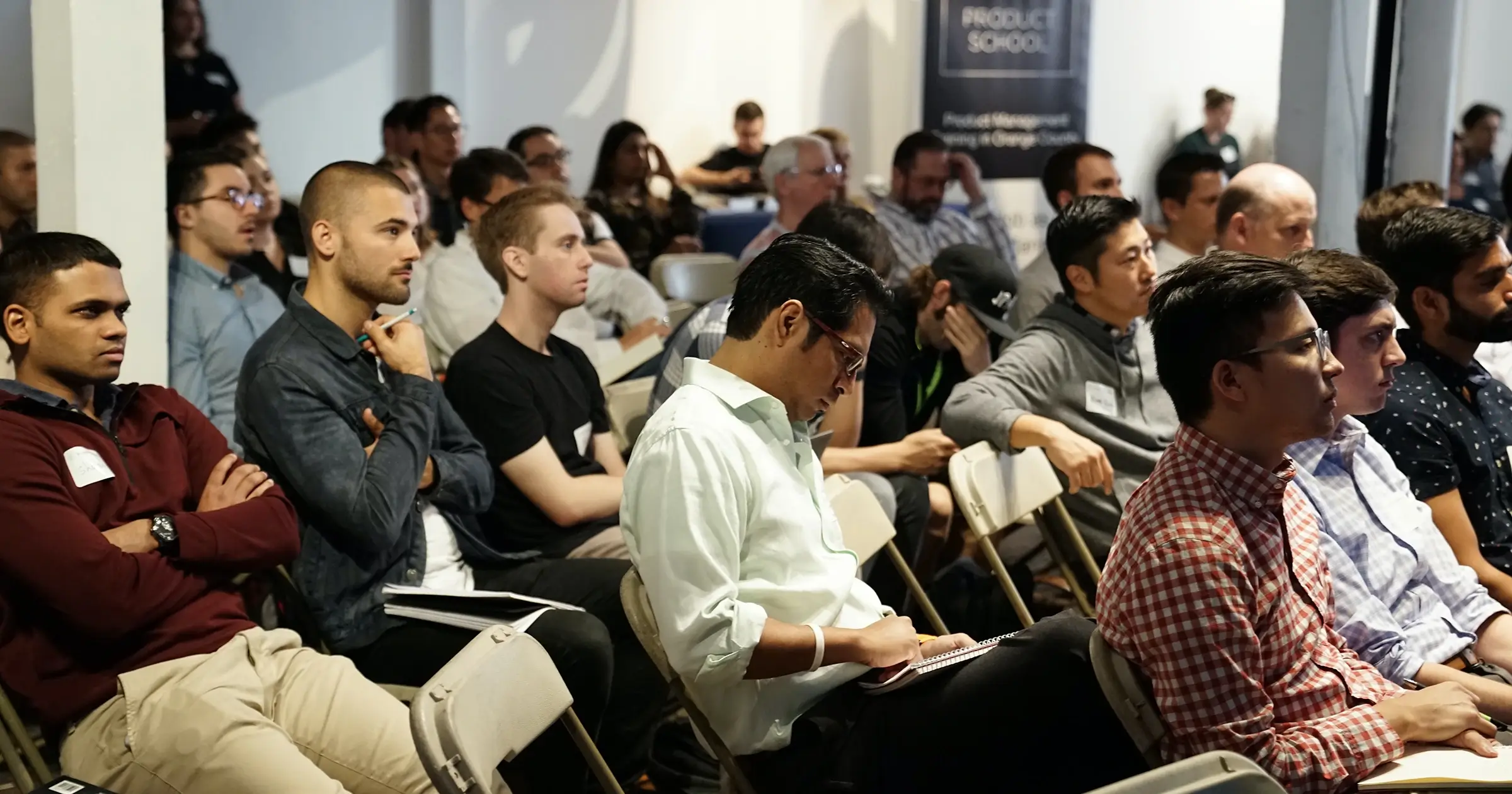 A large group of people listening to a conference speech