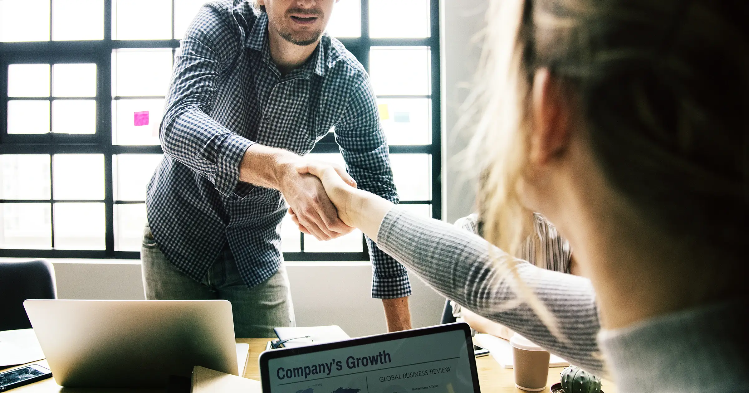 Two people shaking hands in the office