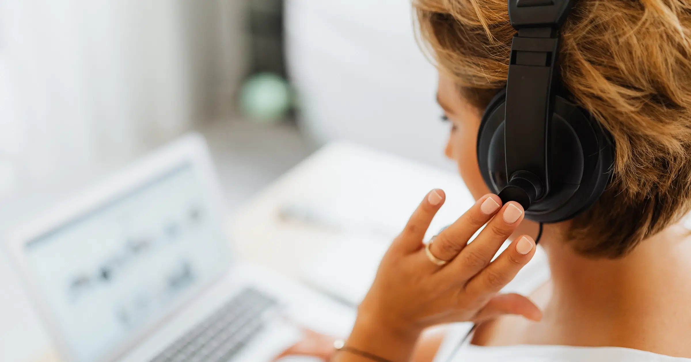 Businesswoman using headphones and laptop