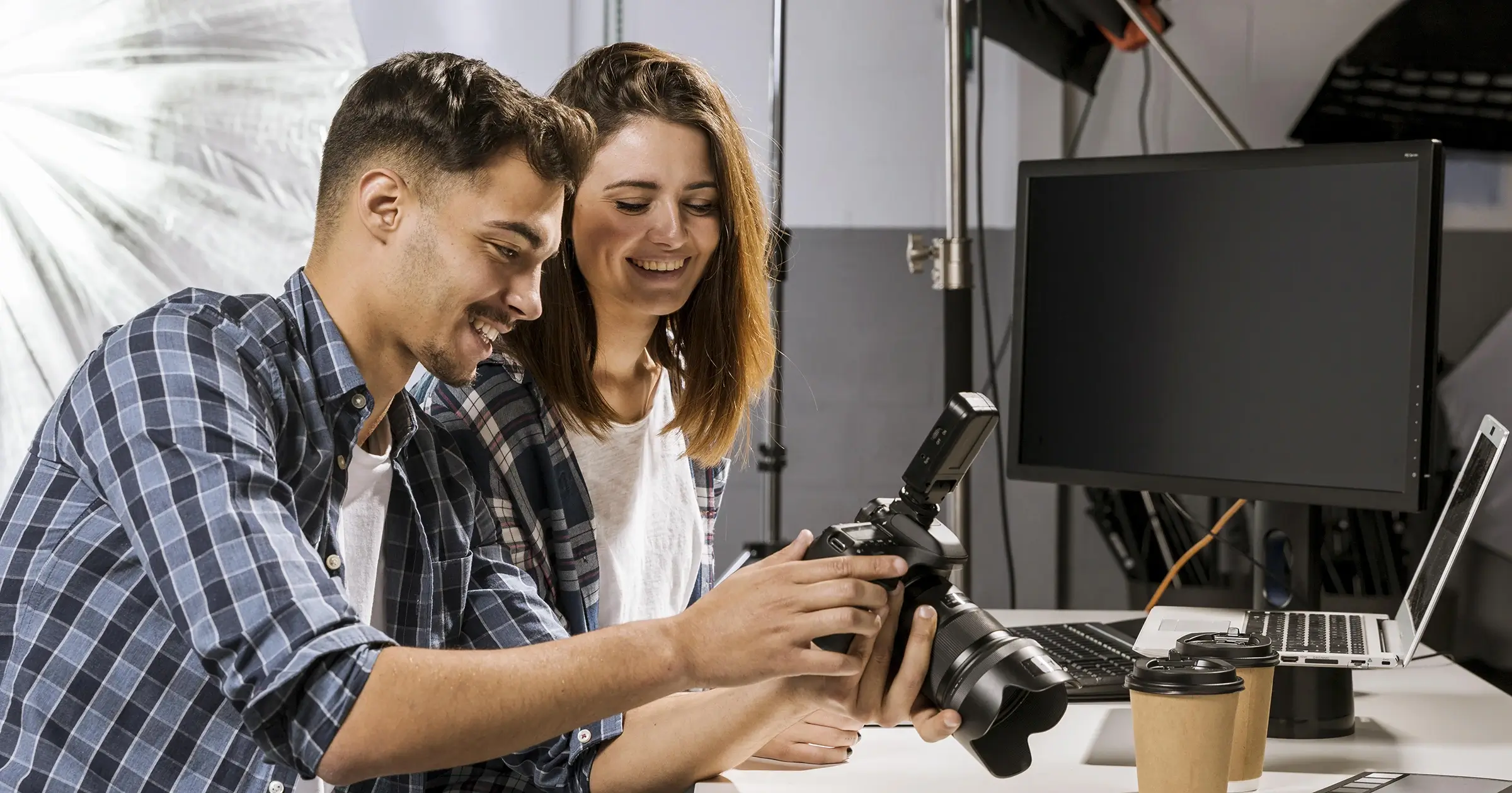 A man and a woman looking at a dslr camera