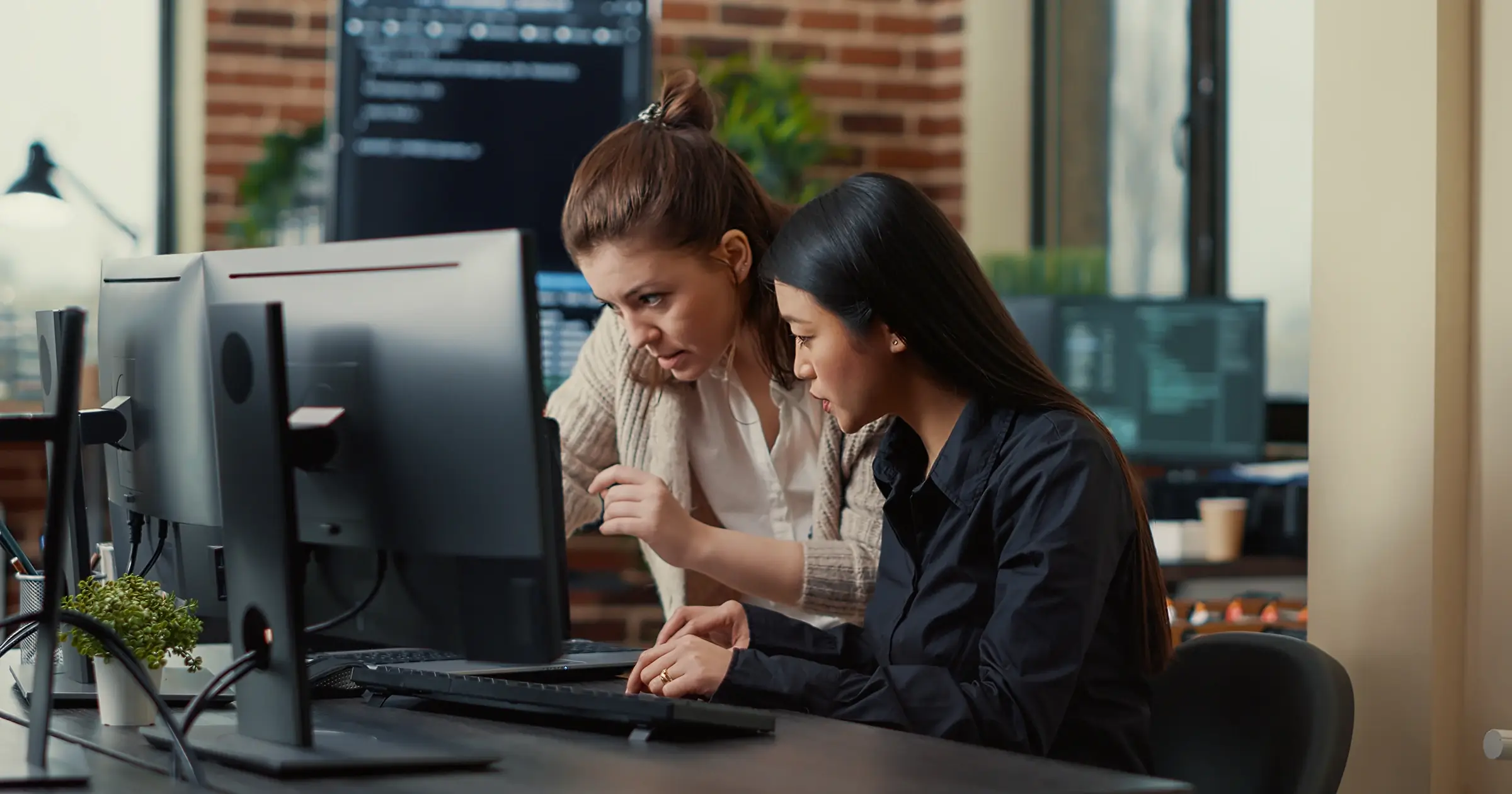 2 women working together at a computer