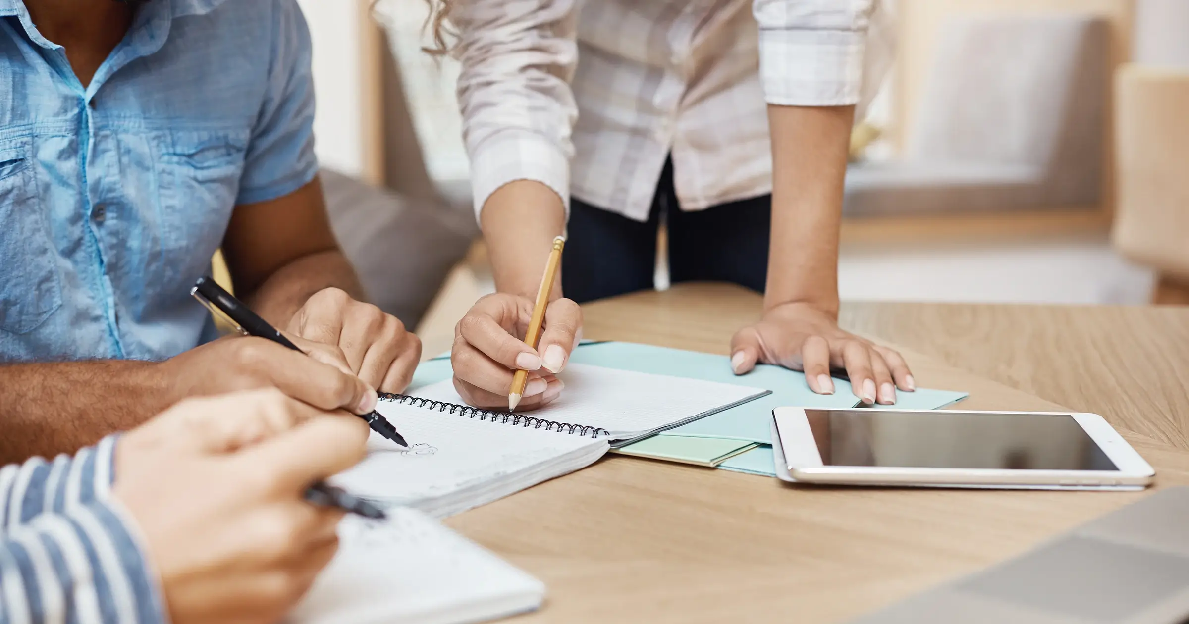 People taking notes as they discuss a project