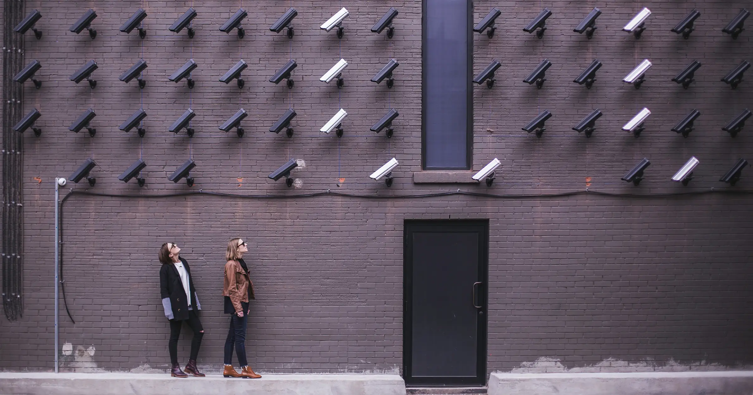 2 people looking up at surveillance cameras