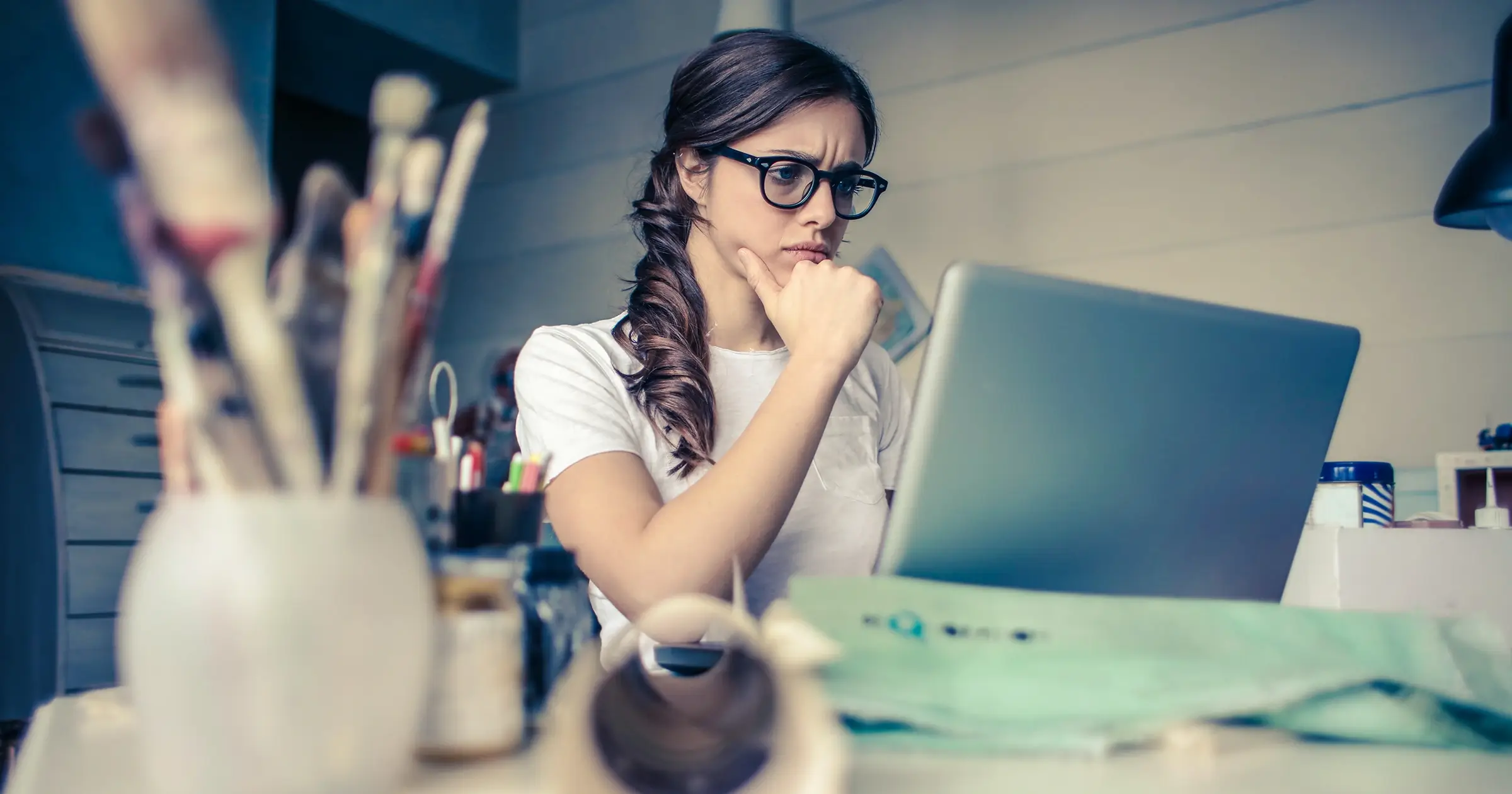 Creative freelancer thinking at her laptop