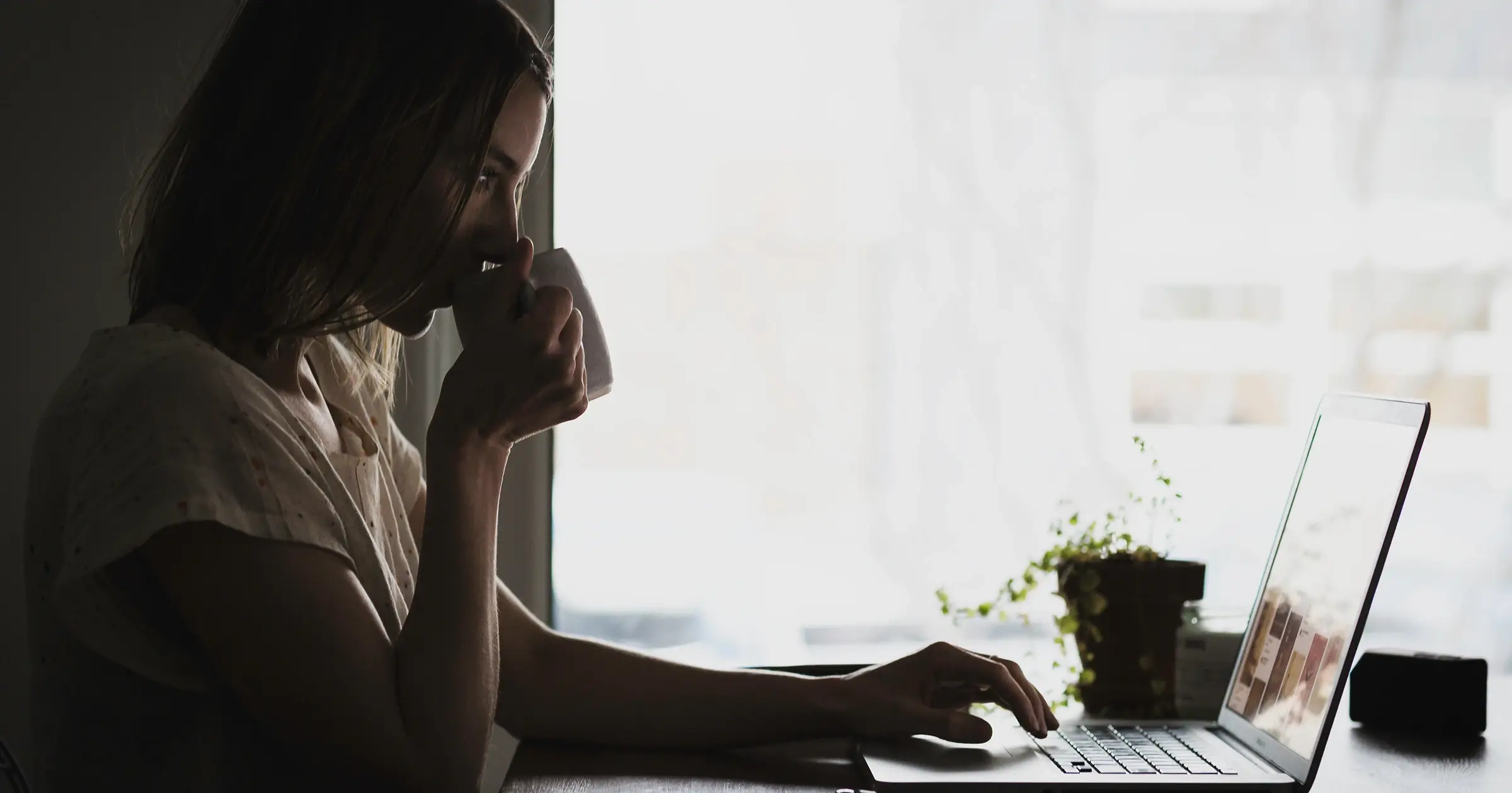 Woman drinking coffee as she works