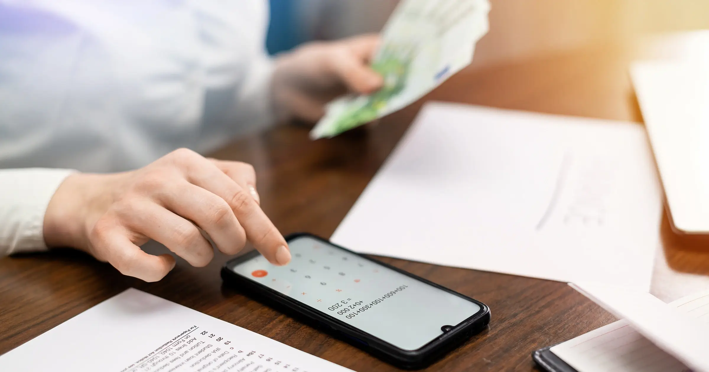 Woman counting cash with a calculator