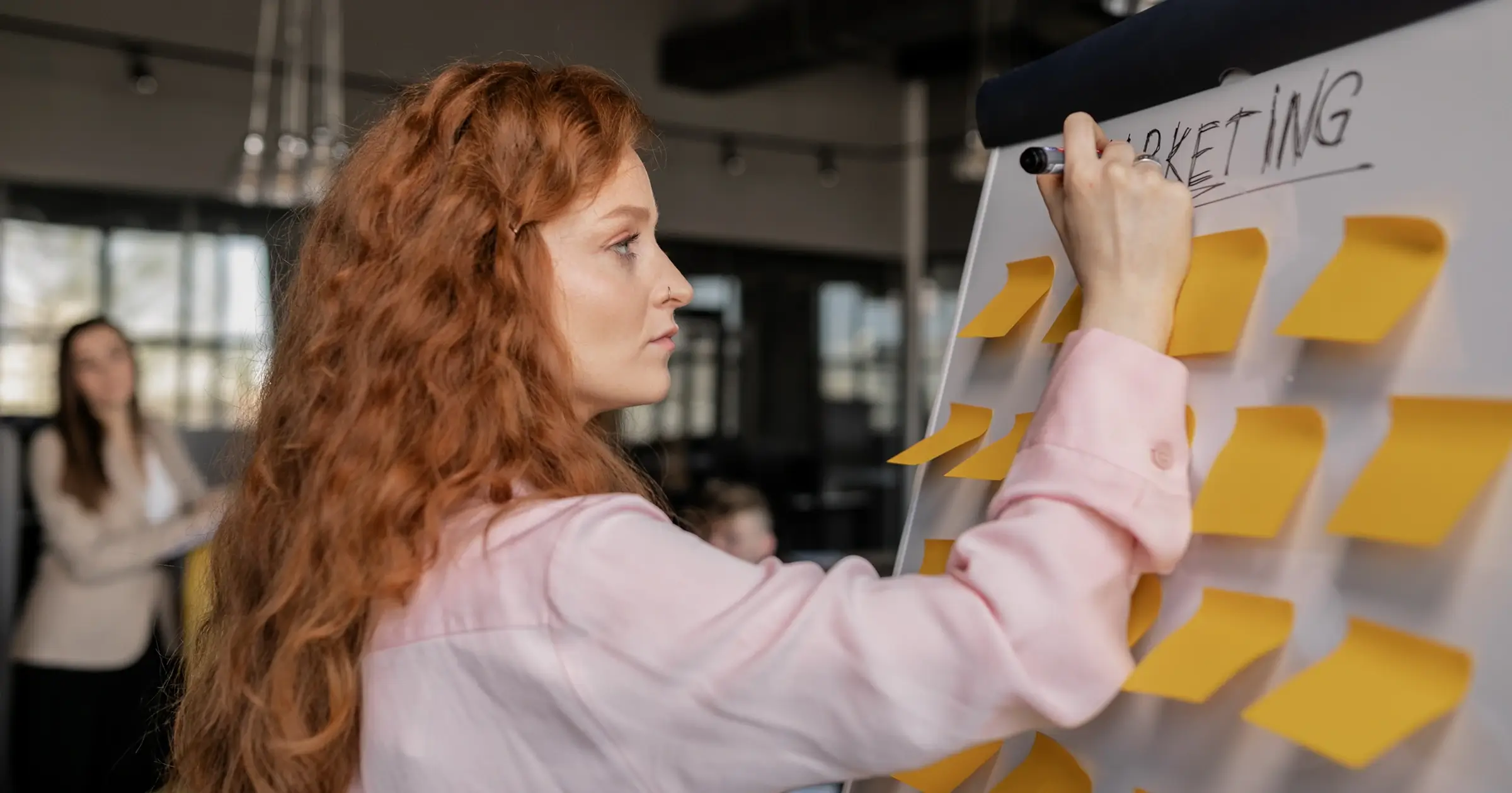 Woman at a whiteboard full of post-its