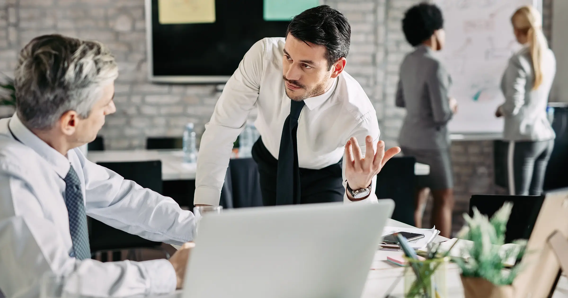 2 people in shirt and ties discussing a project