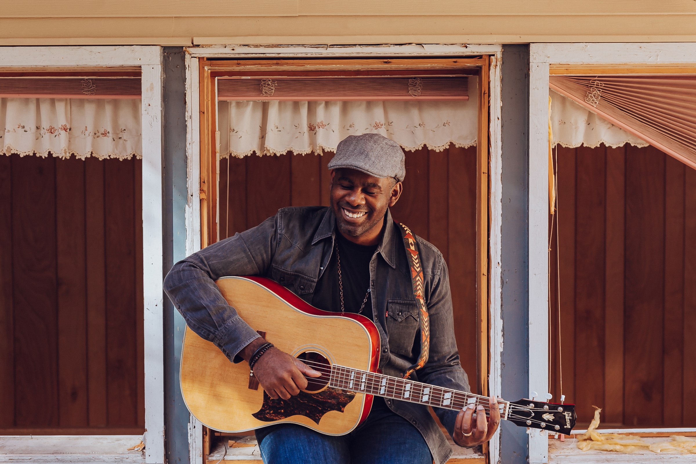 Drew Bordeaux laughing with his guitar