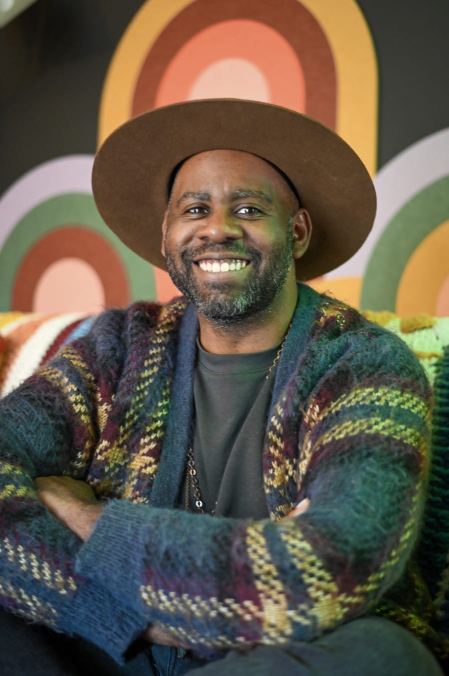 Drew Bordeaux in front of the mural in his studio