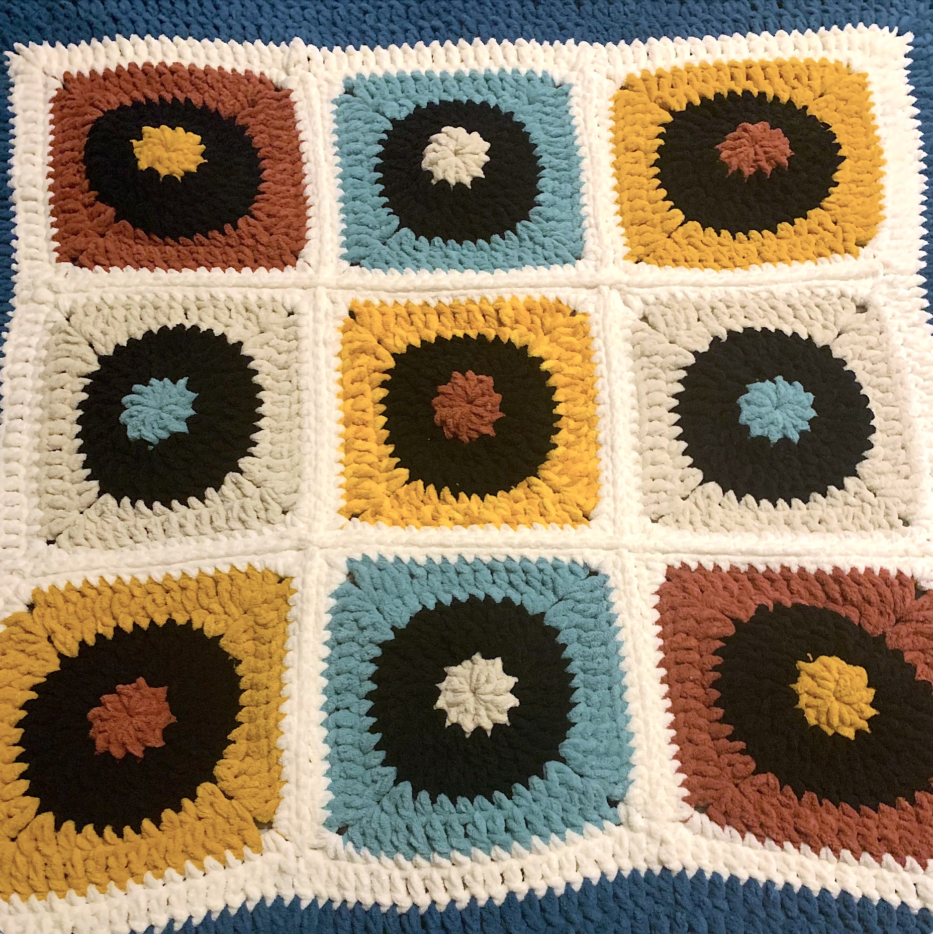 Crochet blanket with vinyl record circle motifs in blue, teal, and gold