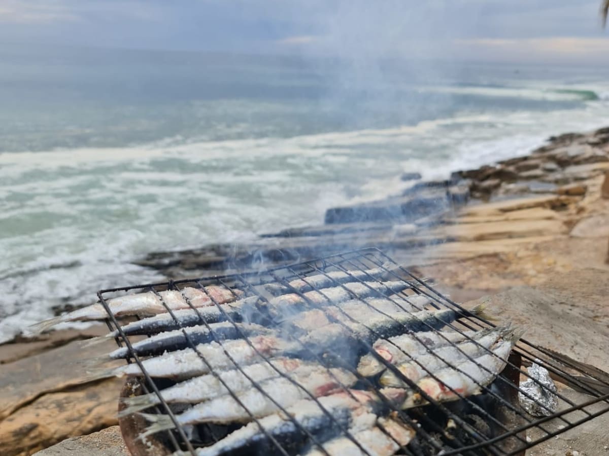 Sardines grillées sur barbecue de terre cuite, face à l'océan