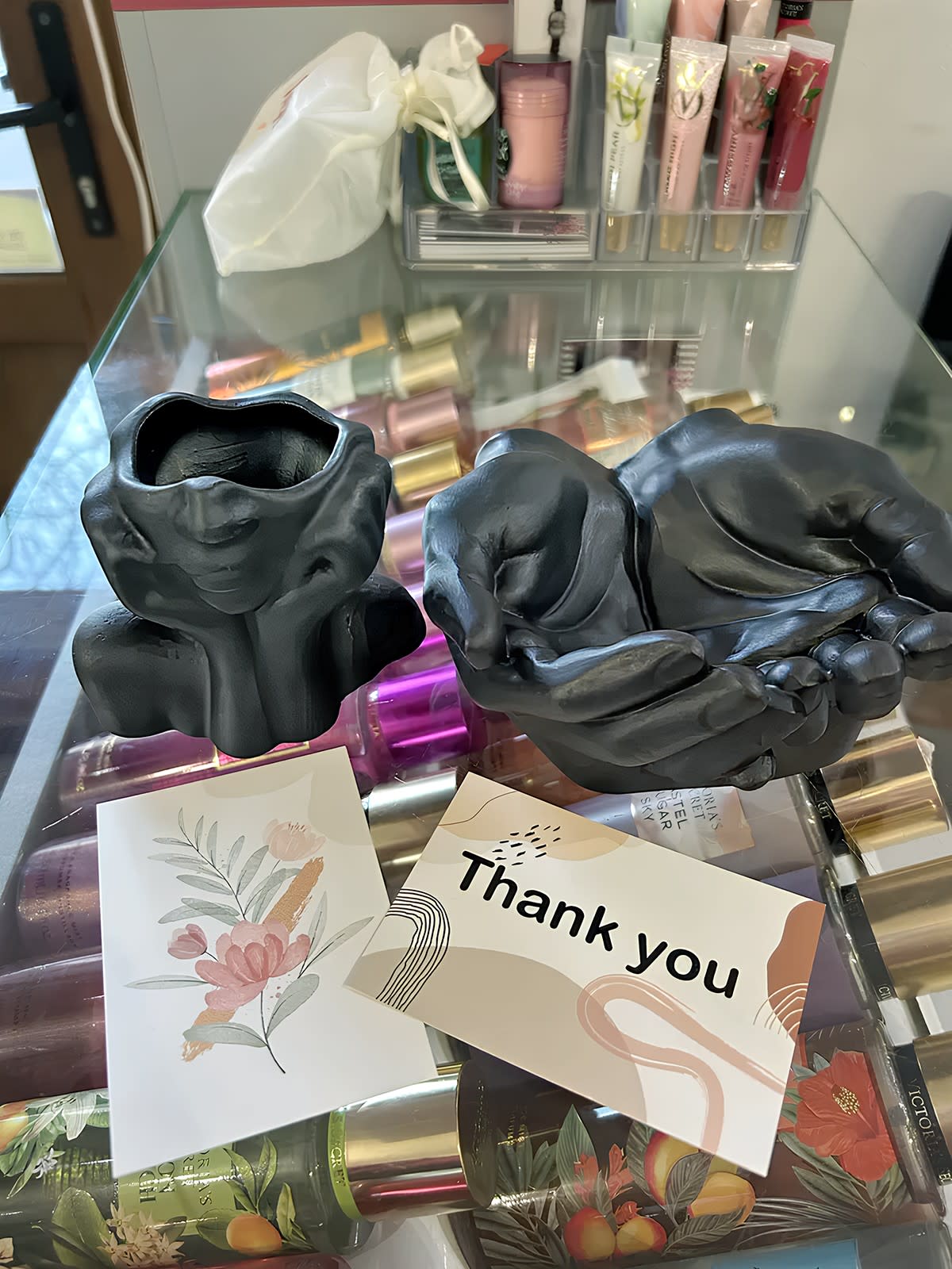 Фото відгук: Чорні гіпсові кашпо Ніжна Мрійниця та Долоні на вітрині з косметикою