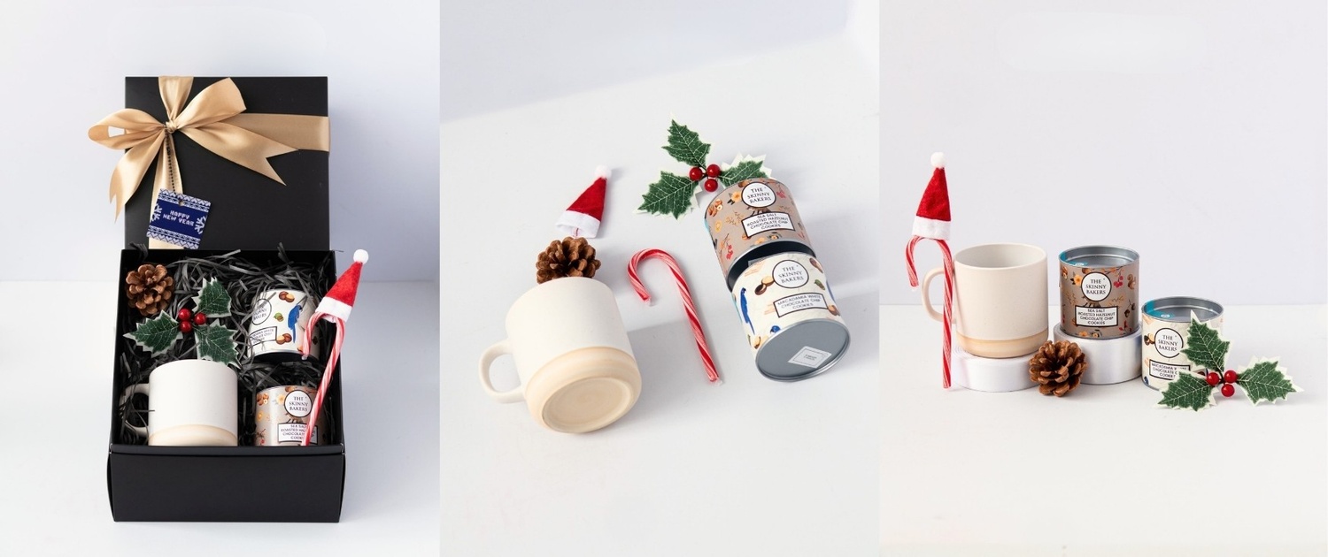 Christmas corporate gifts with christmas theme consists of cookies in jar, candy cane with santa hat, mug and decorations in black gift box with golden ribbon.