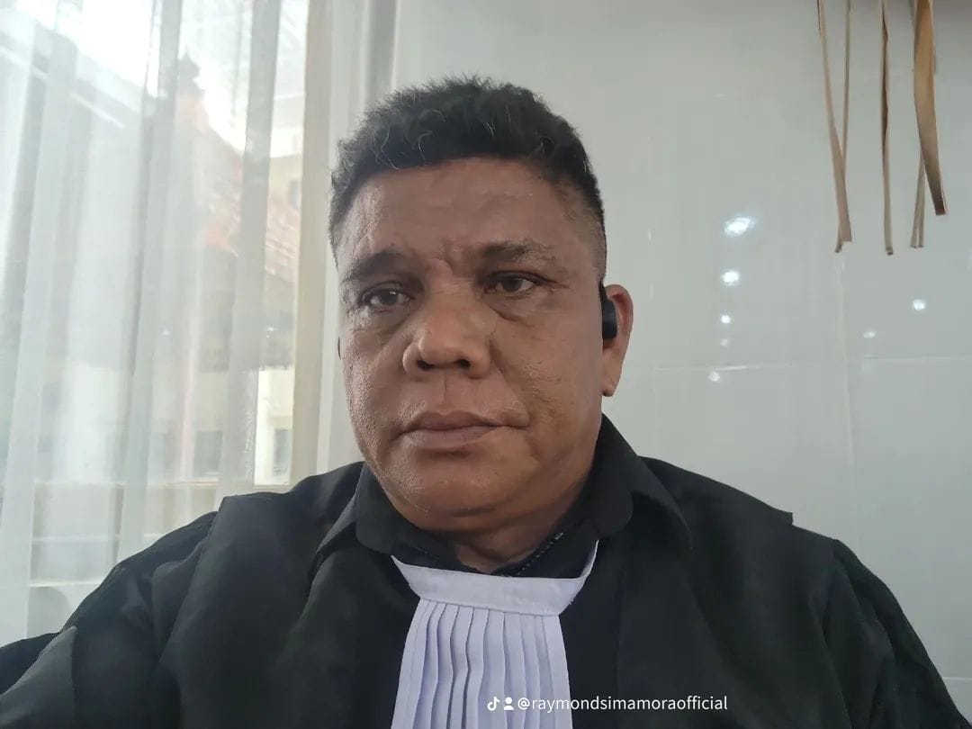 Bapak Raymond Simamora, S.H., M.H. dalam pakaian dinas persidangan lengkap (toga advokat) saat sedang berada di lingkungan pengadilan.