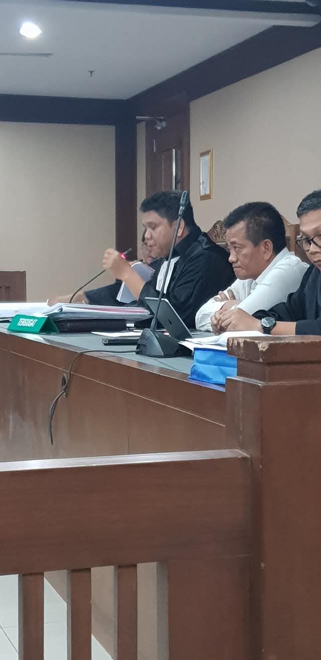 Momen Raymond Simamora, S.H., M.H. saat memberikan pernyataan melalui mikrofon di hadapan majelis hakim dalam persidangan.