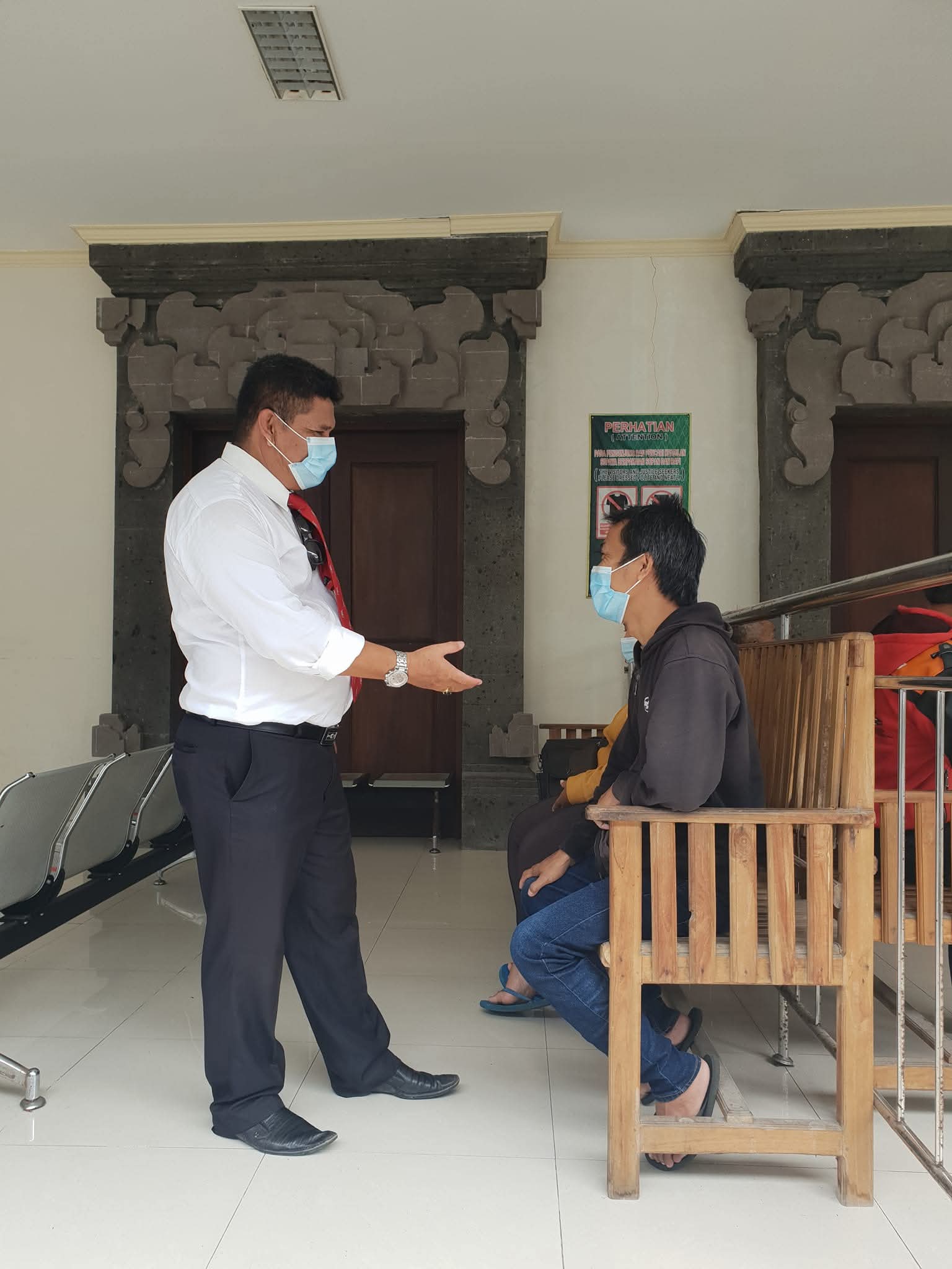 Pelayanan bantuan hukum berupa konsultasi tatap muka oleh Raymond Simamora, S.H., M.H. (berkemeja putih) dengan klien di ruang tunggu gedung pengadilan.