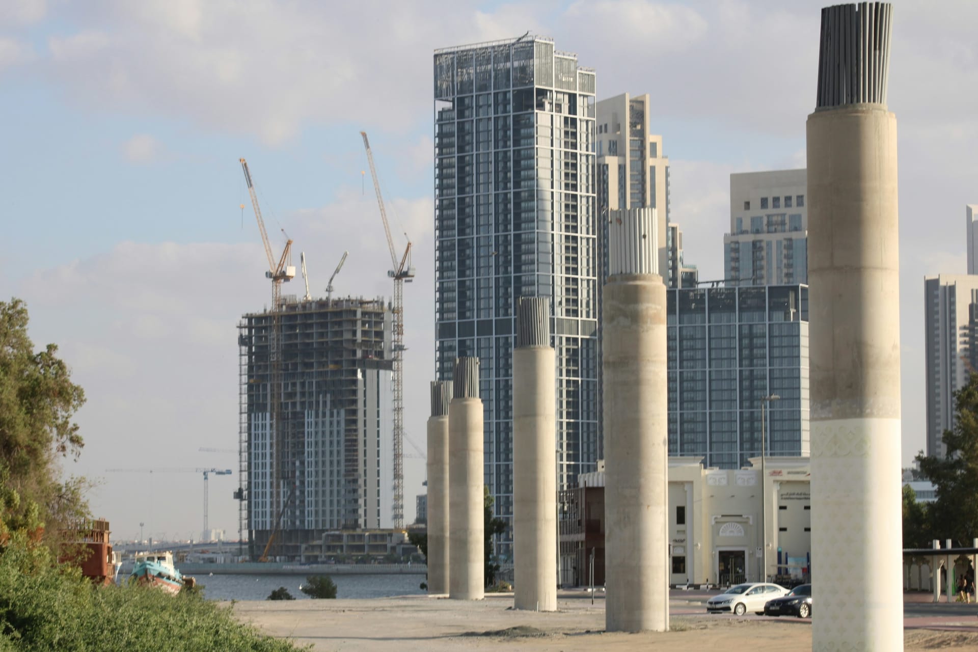 City skyline across water with towers under construction