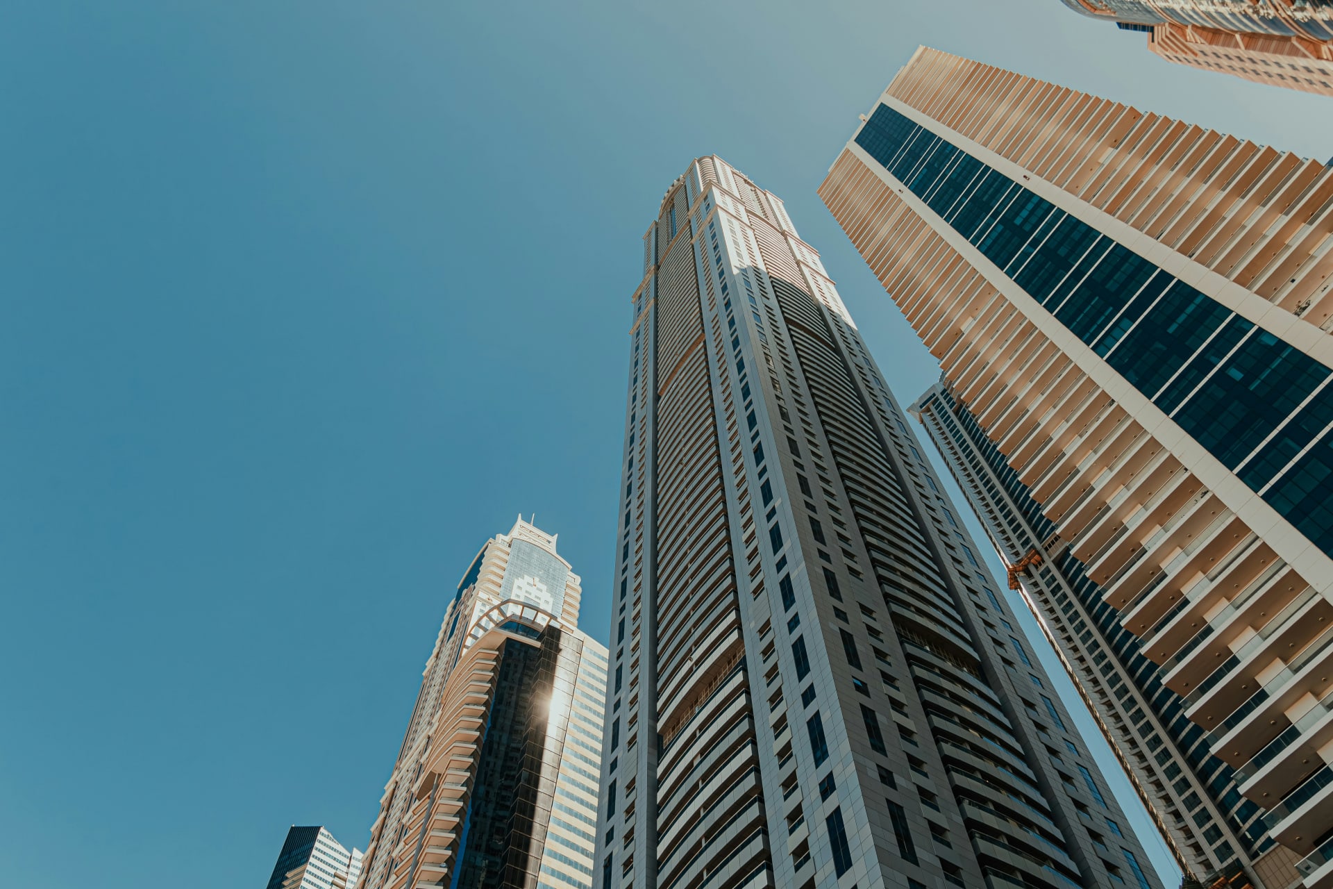 Looking up at modern high-rise towers against a clear sky