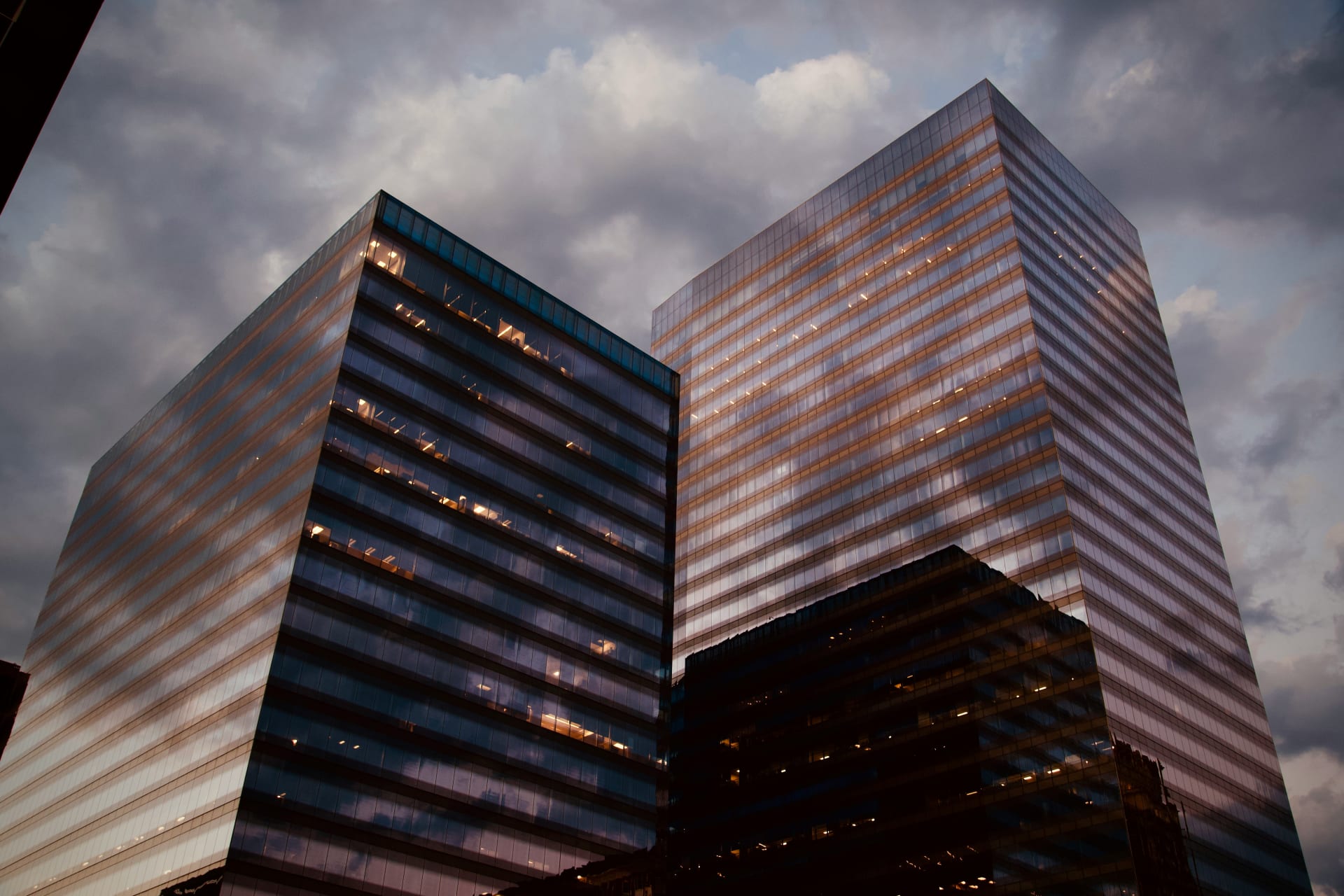 Glass office towers lit against a dark evening sky