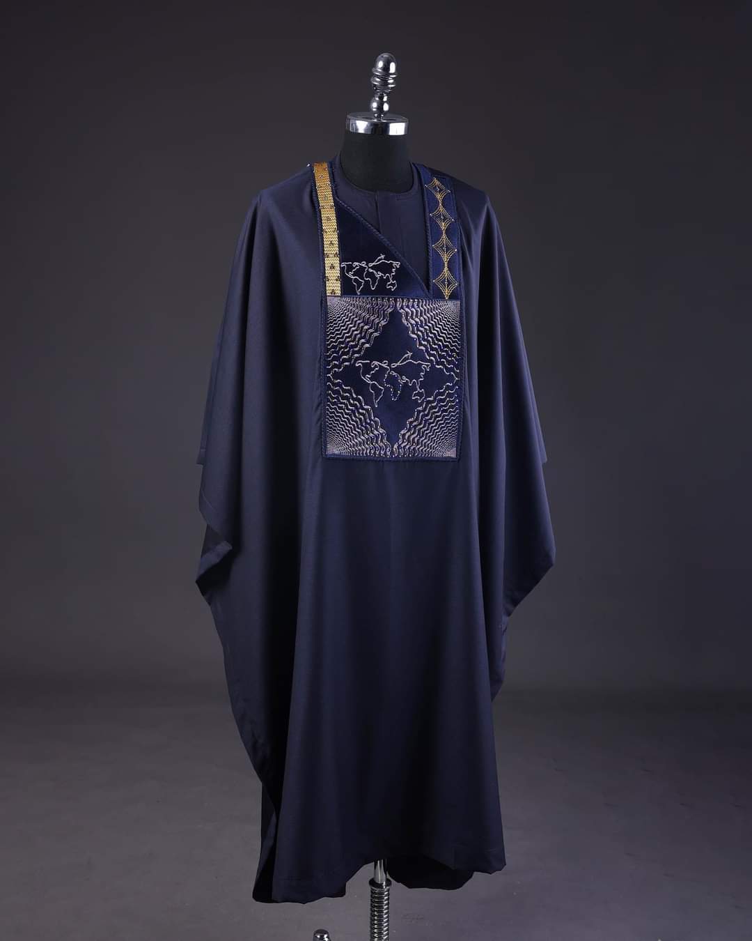 Navy agbada with a silver embroidered chest panel and gold trim, displayed on a mannequin