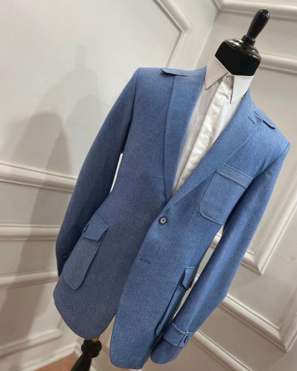Light blue single-breasted blazer with flap pockets over a white shirt, on a mannequin