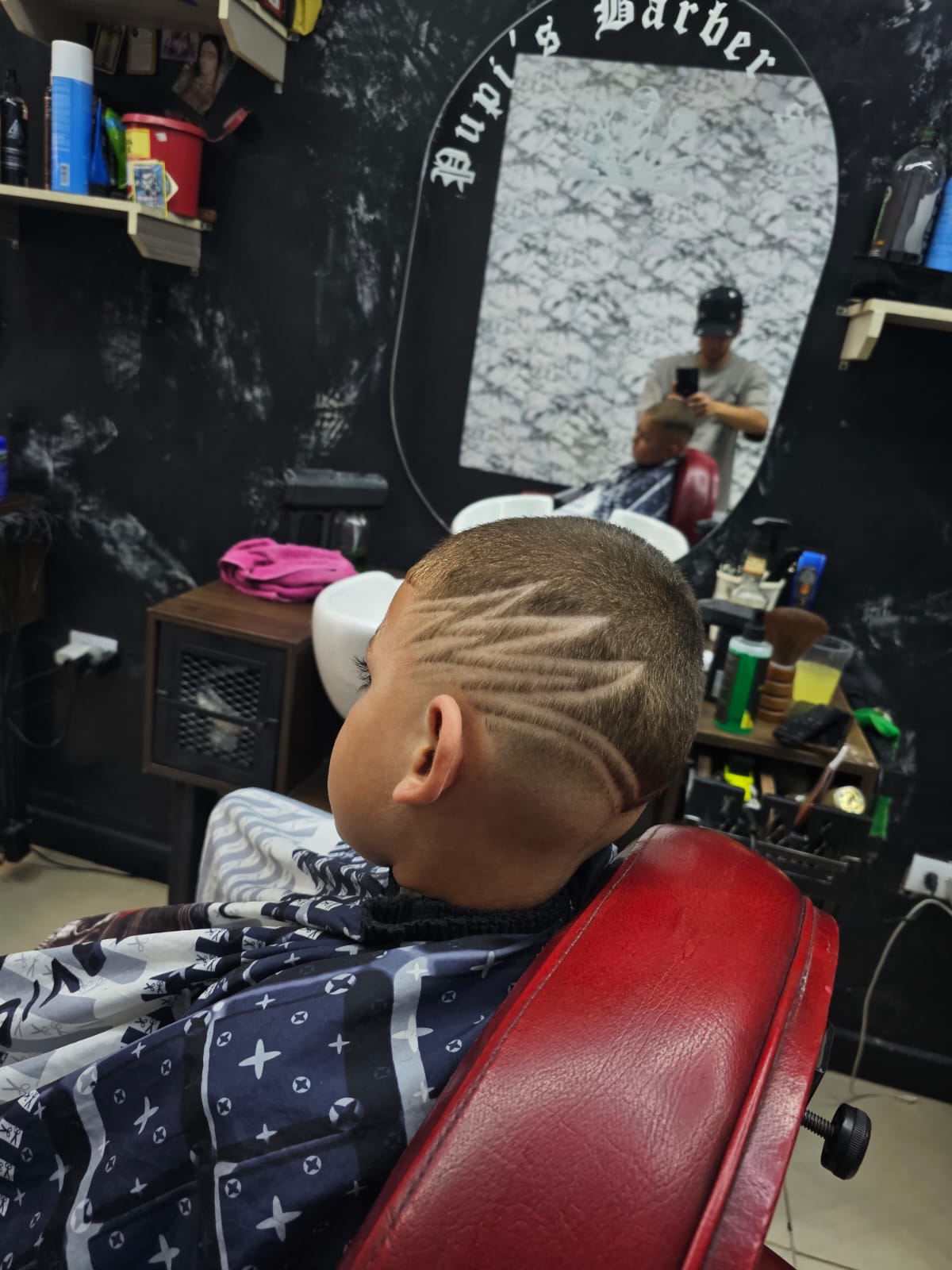 Niño feliz tras corte en Pupi's Barbershop