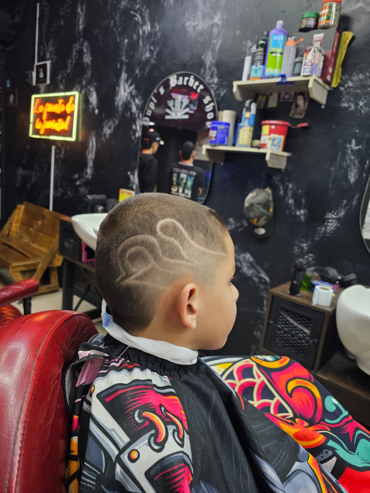 Niño en sesión de corte en Pupi's Barbershop