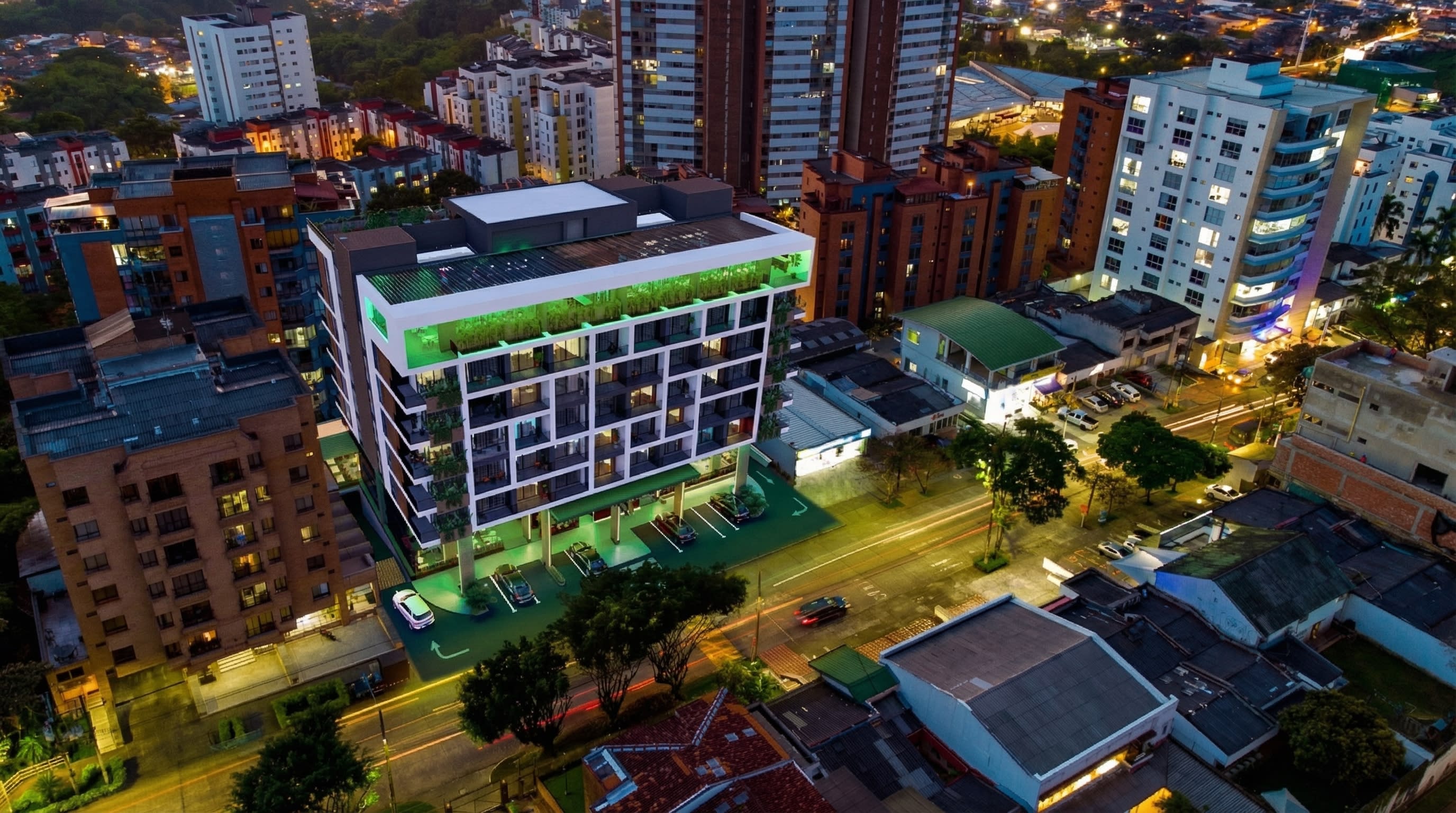 Vista aérea nocturna de Volterra Plaza Suites iluminado sobre el corredor de la Calle 14 en Álamos, Pereira.