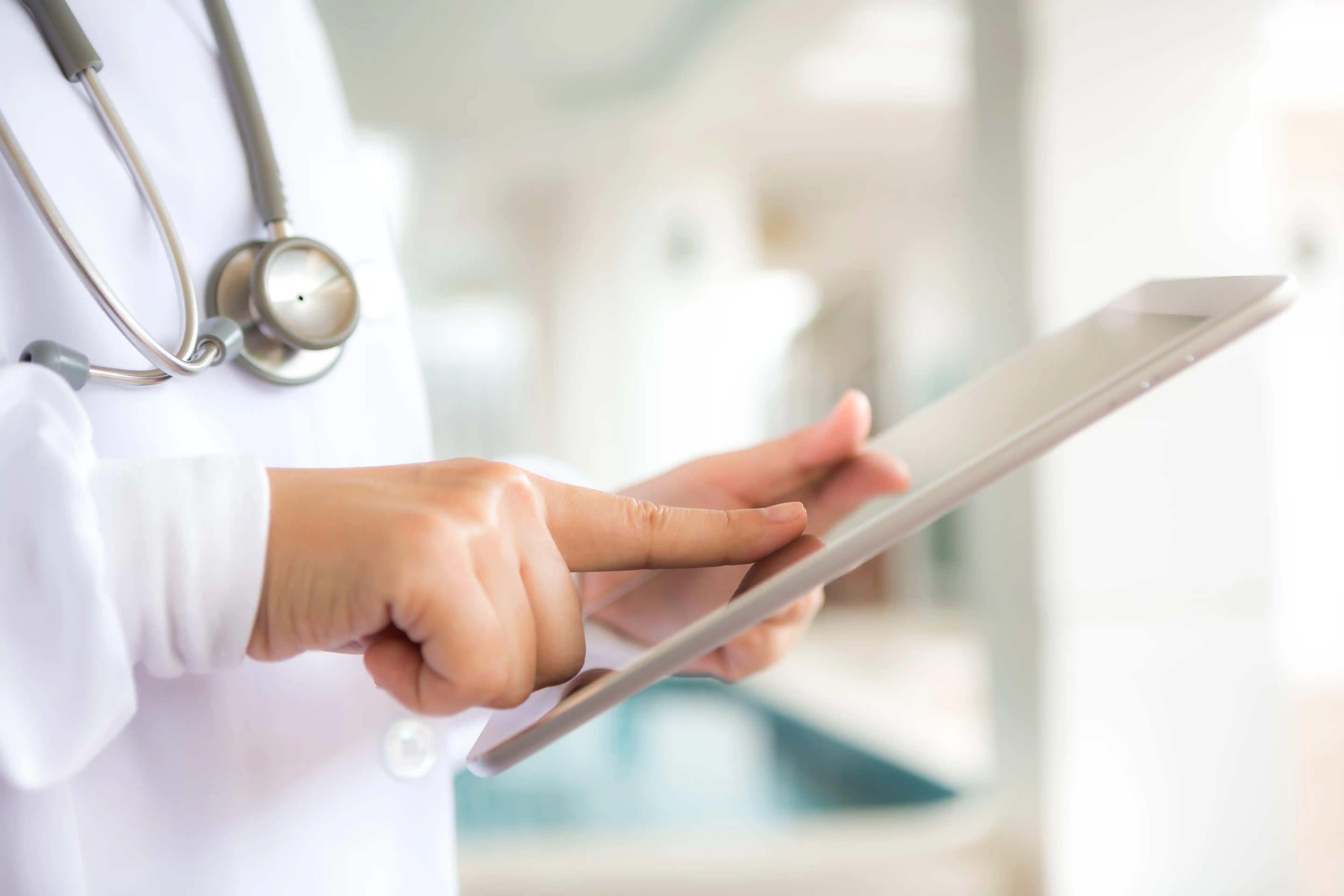 Doctor using patient record system on tablet during a consultation in Pakistan