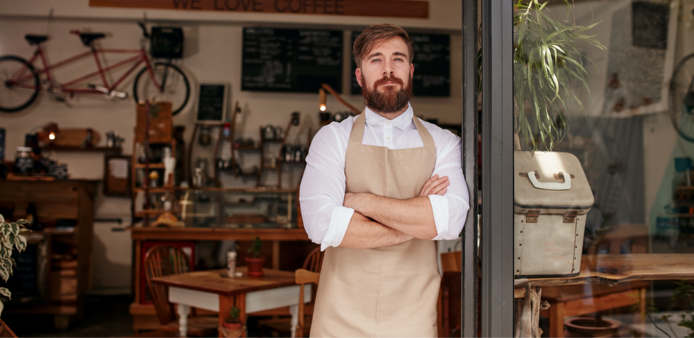 A man in front his cafe