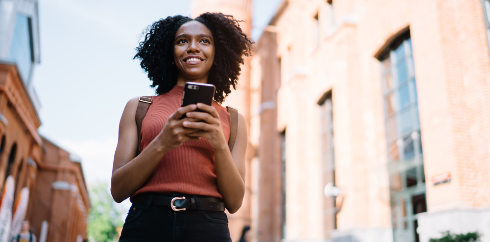 A positive looking young woman with a phone