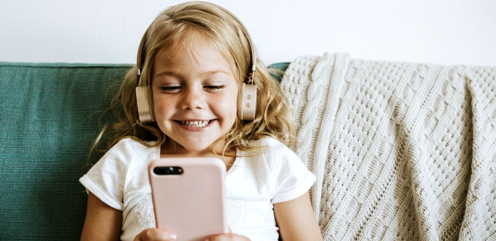 A kid playing a game on her phone