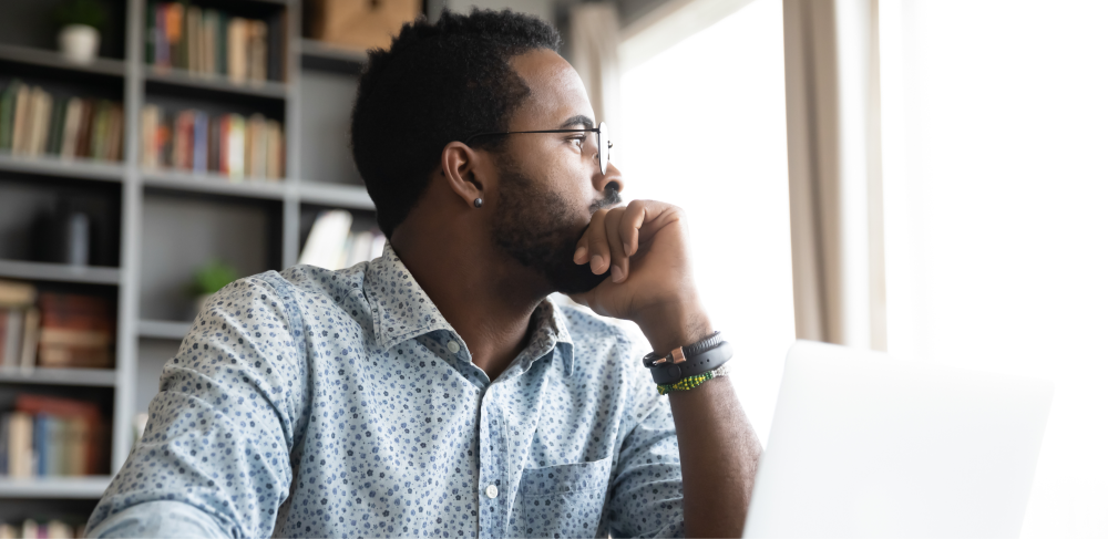 A man thinking in front of his laptop