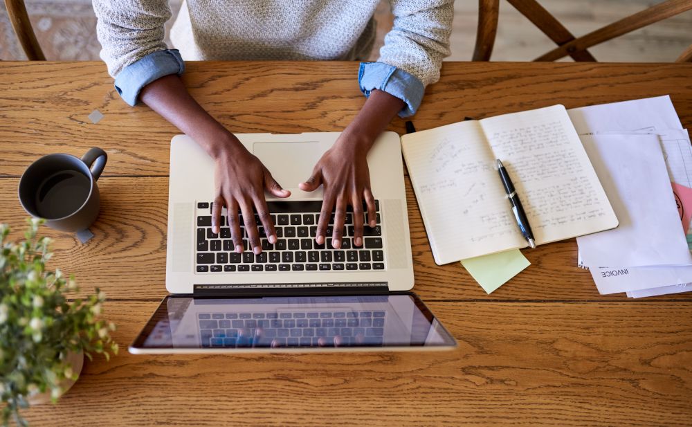 a desk with laptop and notebooks