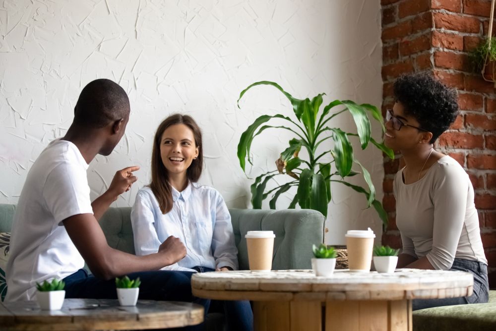 Smiling friends talk have fun in coffeeshop