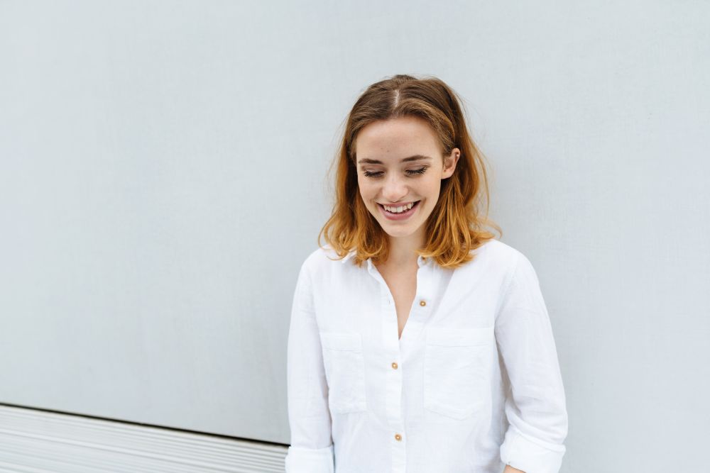 Young woman standing with downcast eyes