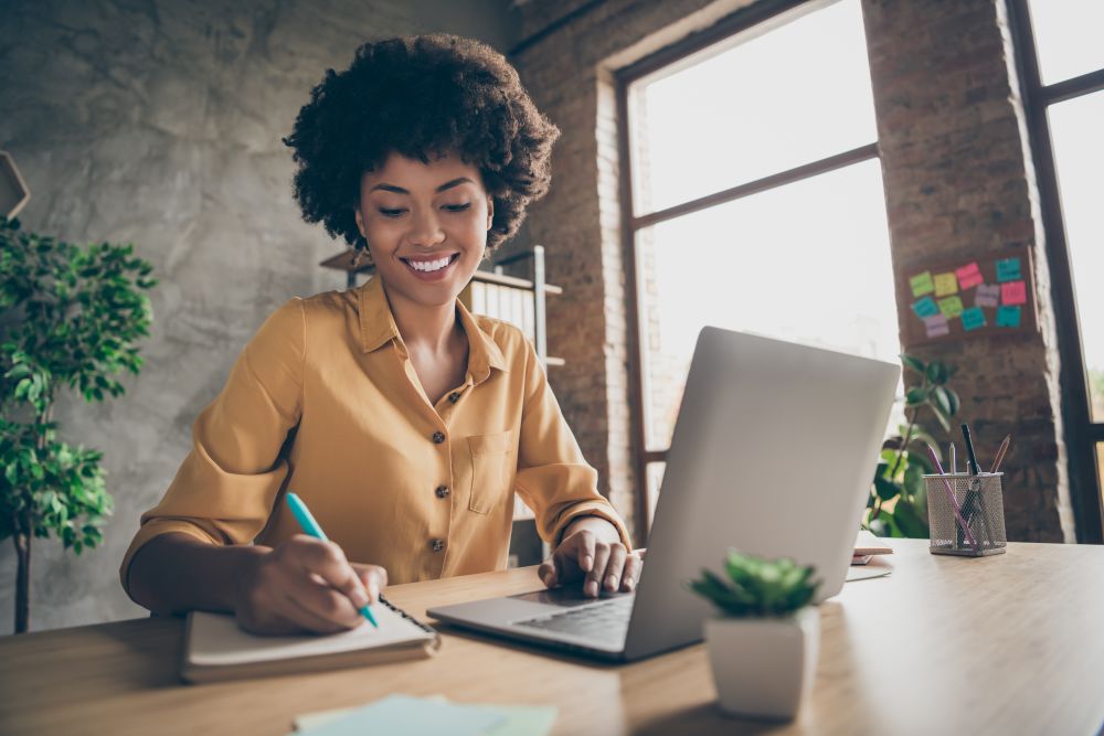 woman on laptop writing notes