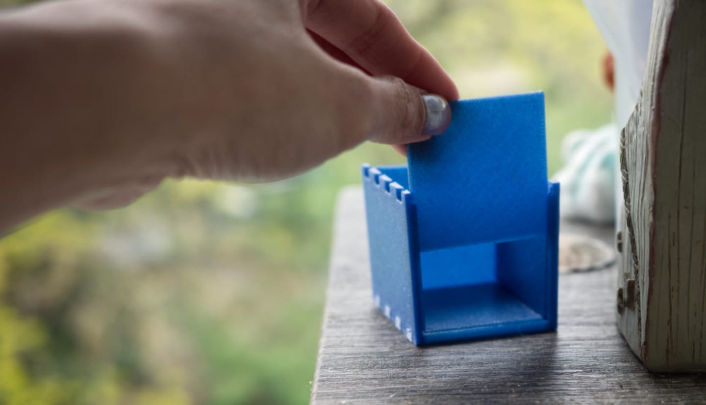 a photo of a hand holding open the sliding cover of the 3d printed box